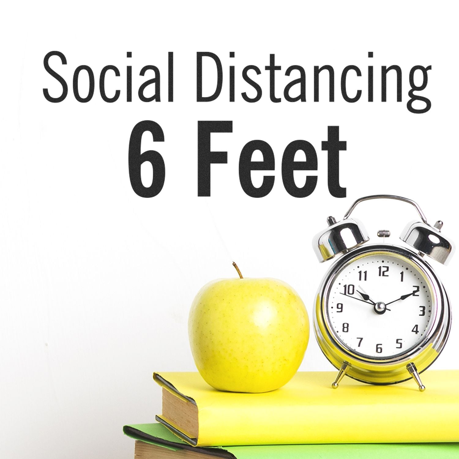 Social Distancing 6 Feet rubber stamp next to a green apple, alarm clock, and books on a white background.