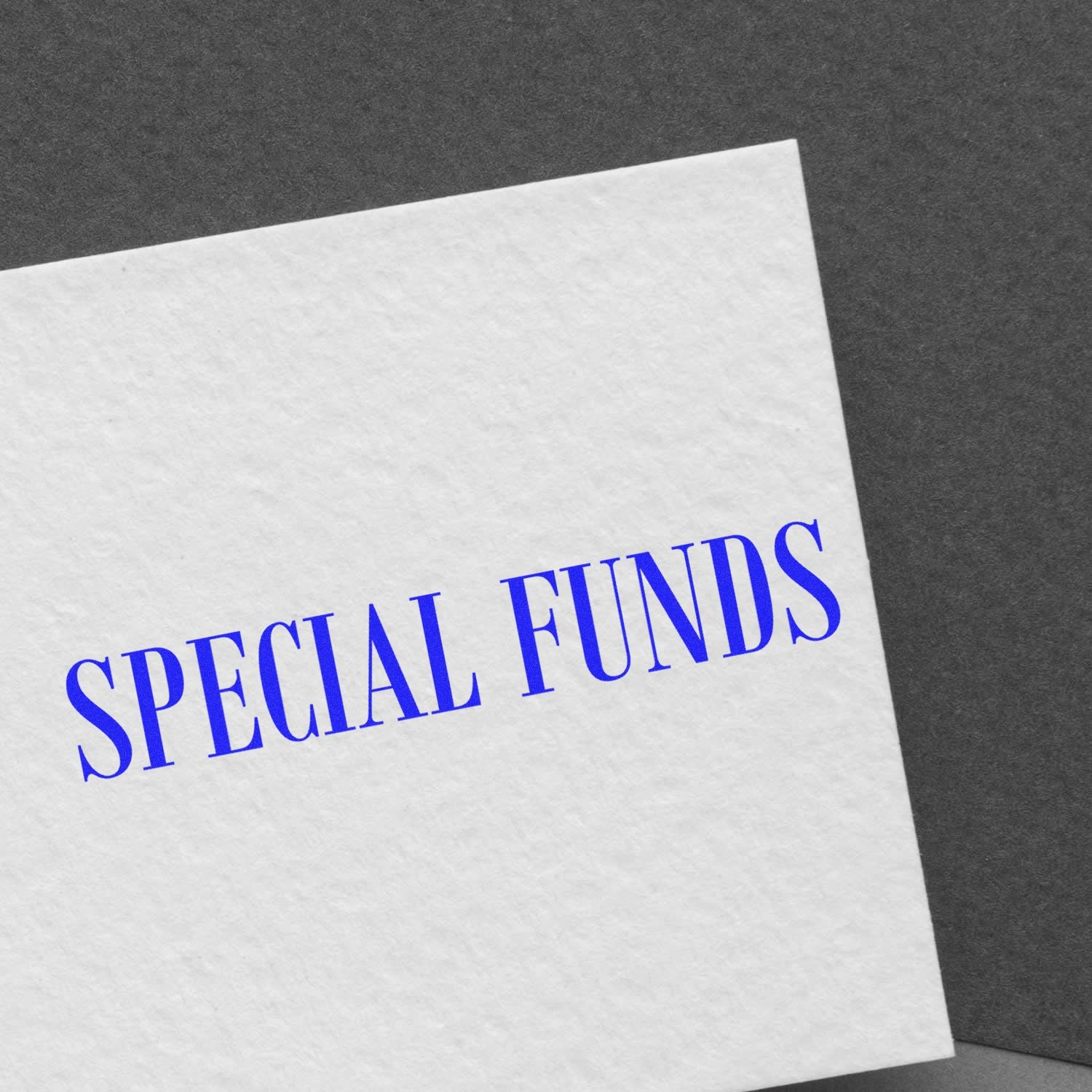 A white card stamped with a blue 'SPECIAL FUNDS' rubber stamp on a dark gray background.