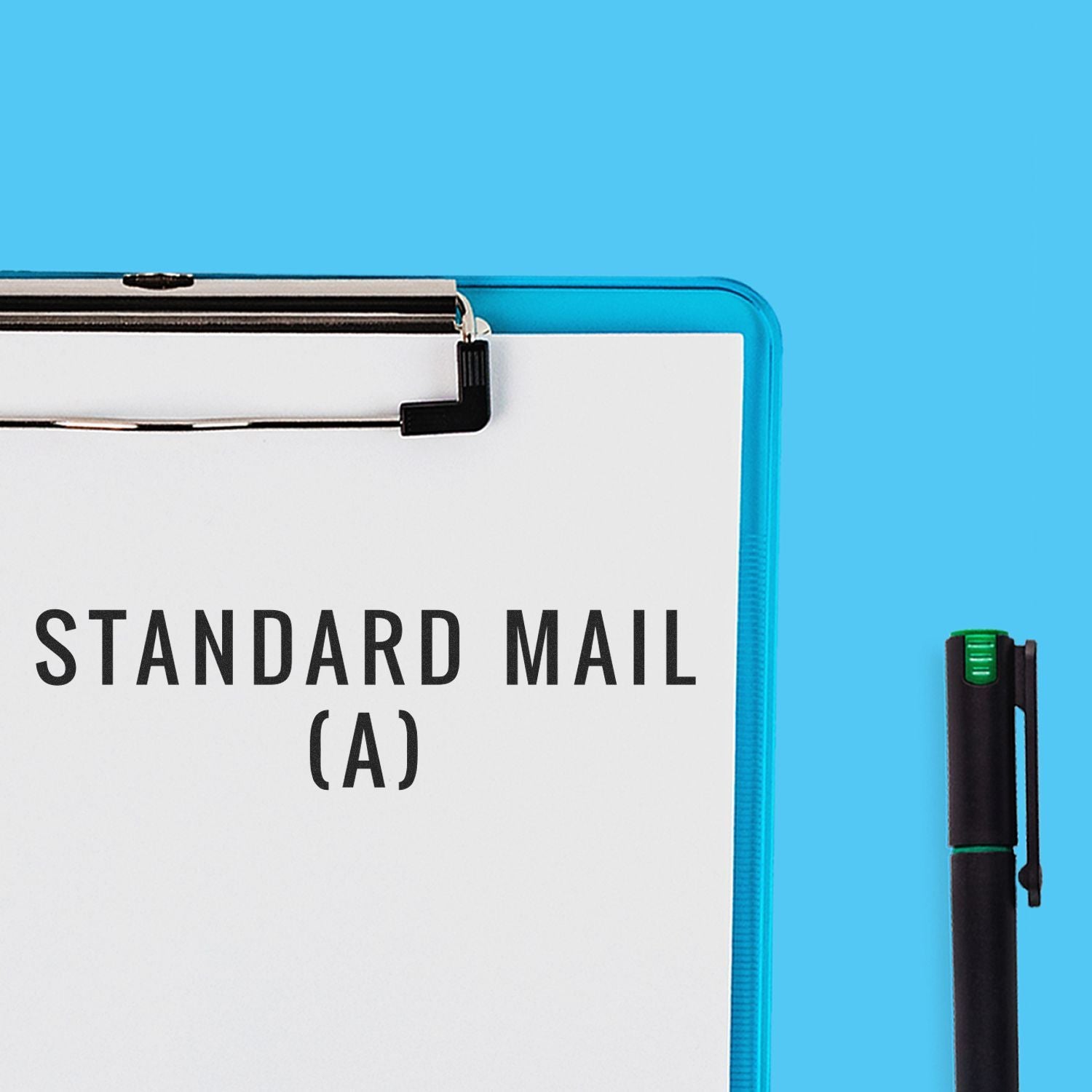 Large Self Inking Standard Mail (A) Stamp used on a white paper clipped to a blue clipboard, with a black pen beside it on a blue background.