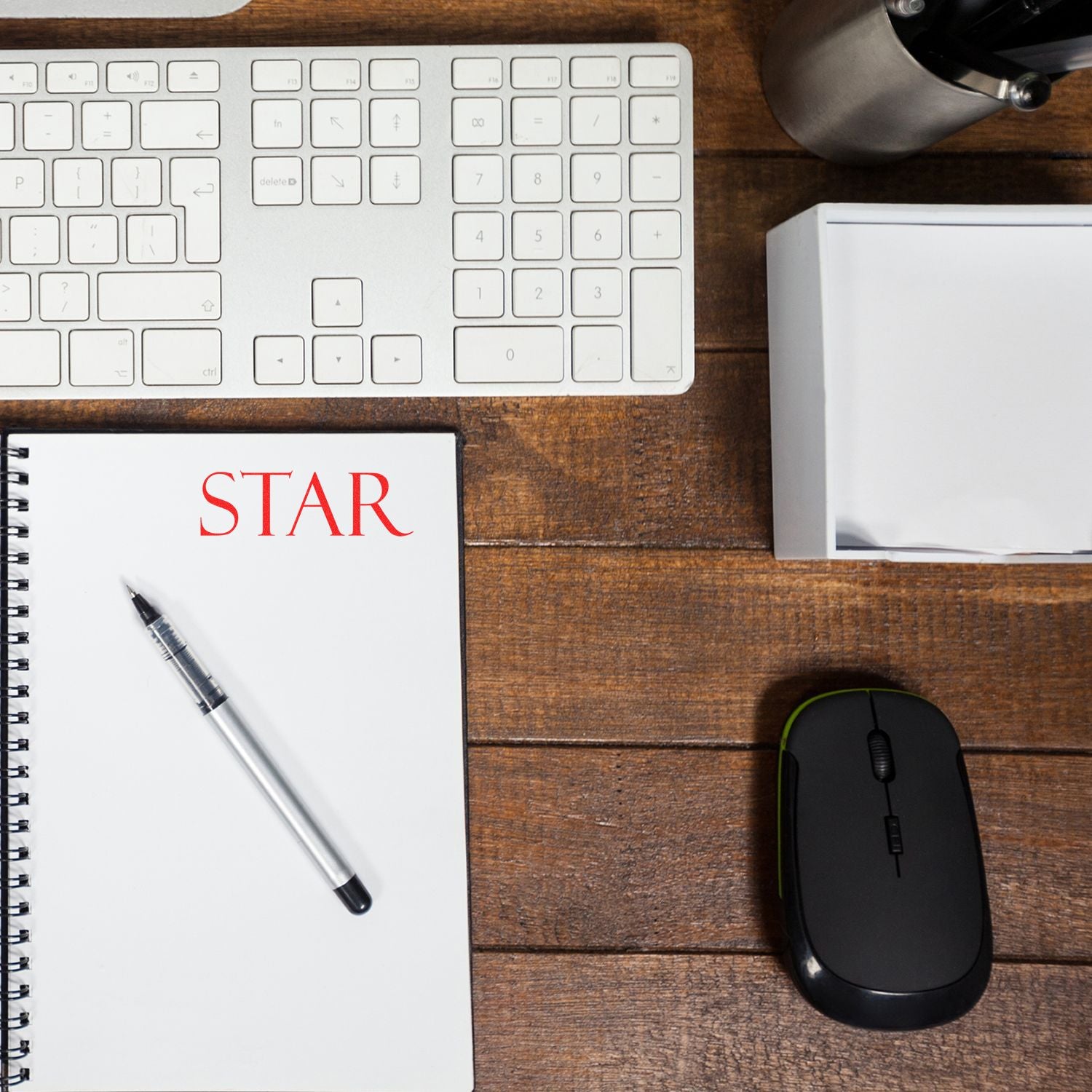 Slim Pre-Inked Star Stamp used on a notebook with a pen, keyboard, mouse, and office supplies on a wooden desk.