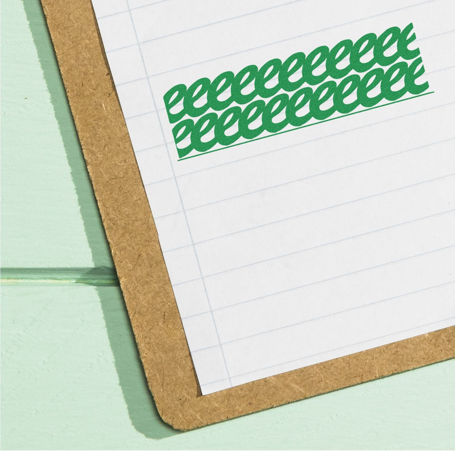 A lined paper with green e marks created by the Large Self Inking Strikeout Stamp, placed on a light green surface with a brown clipboard.