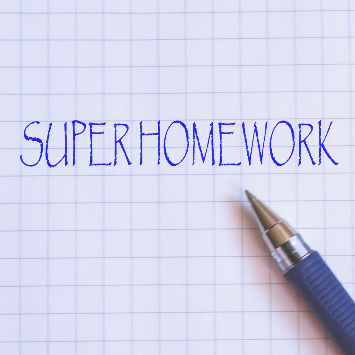 Self Inking Super Homework Stamp in blue ink on graph paper, with a blue pen beside the stamped text.