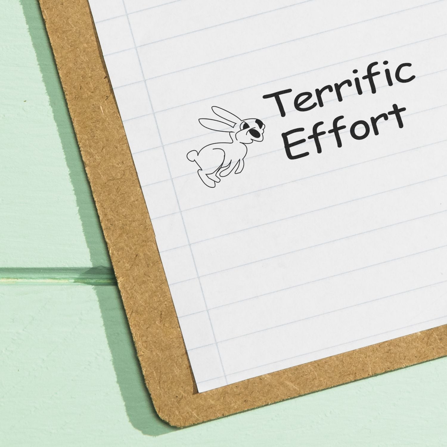 Terrific Effort rubber stamp on lined paper with a cool bunny wearing sunglasses, placed on a clipboard against a mint green background.