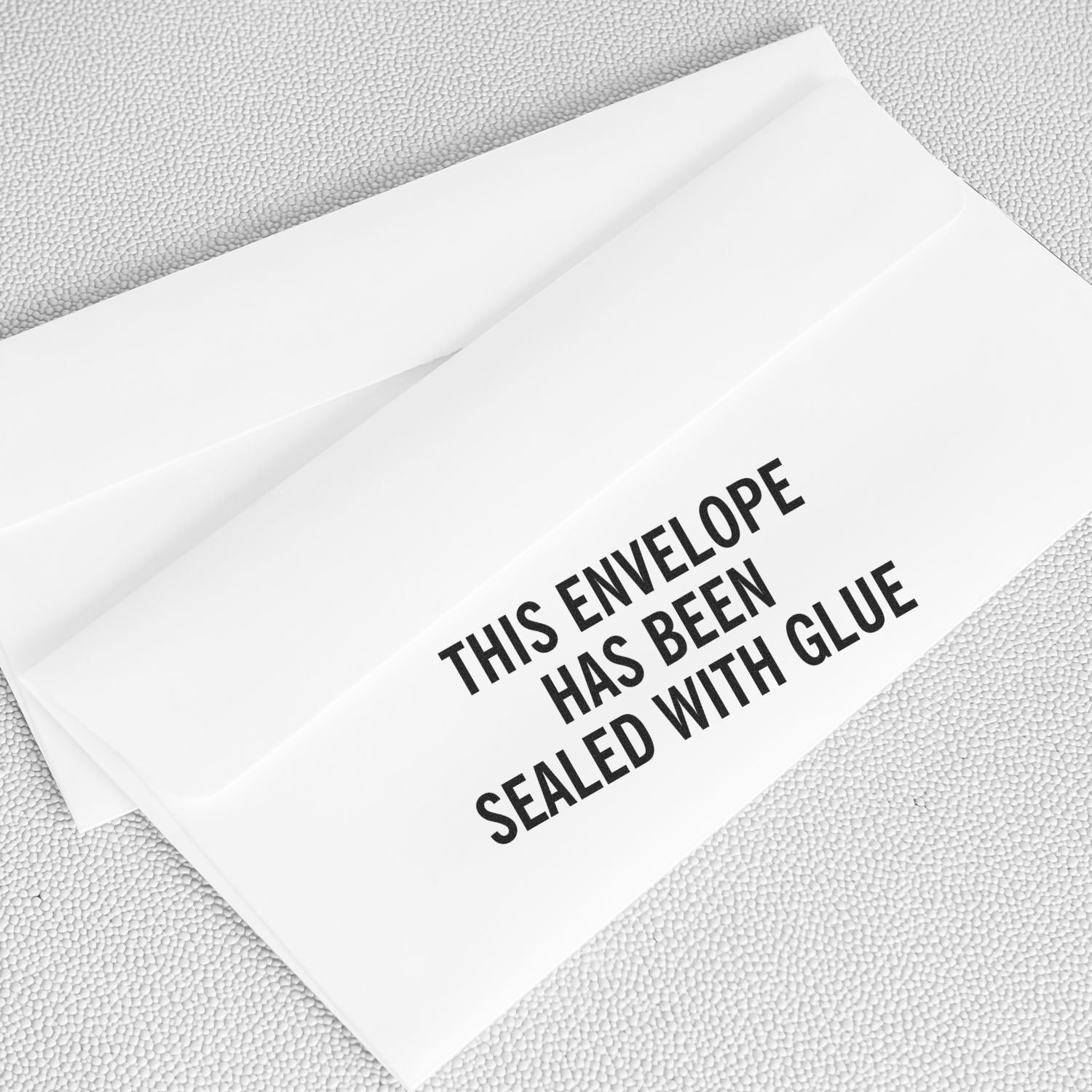 Large This Envelope Has Been Sealed rubber stamp on a white envelope, emphasizing the message in bold black text.