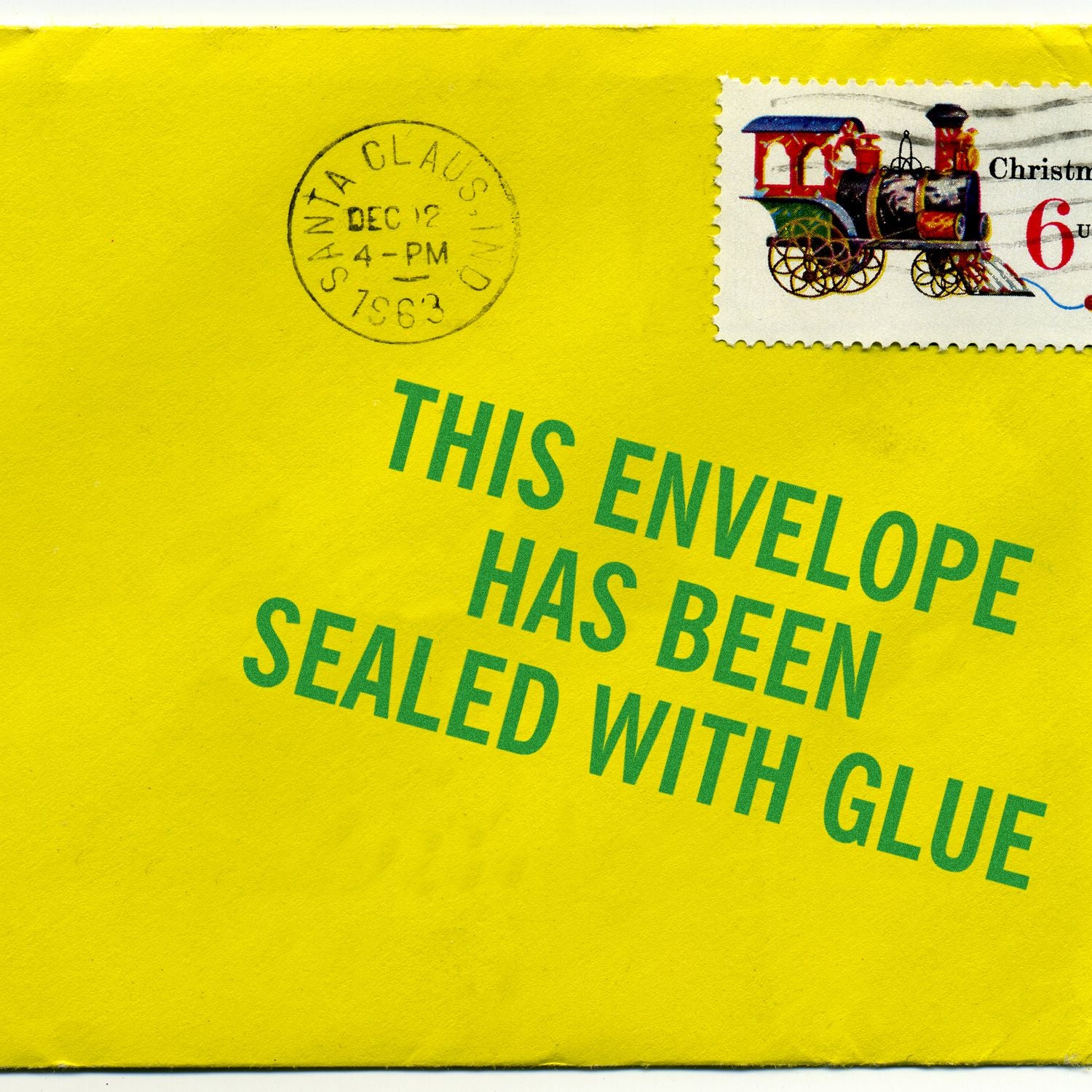 Yellow envelope stamped with This Envelope has been Sealed using the Self Inking This Envelope has been Sealed Stamp, featuring a Christmas stamp.