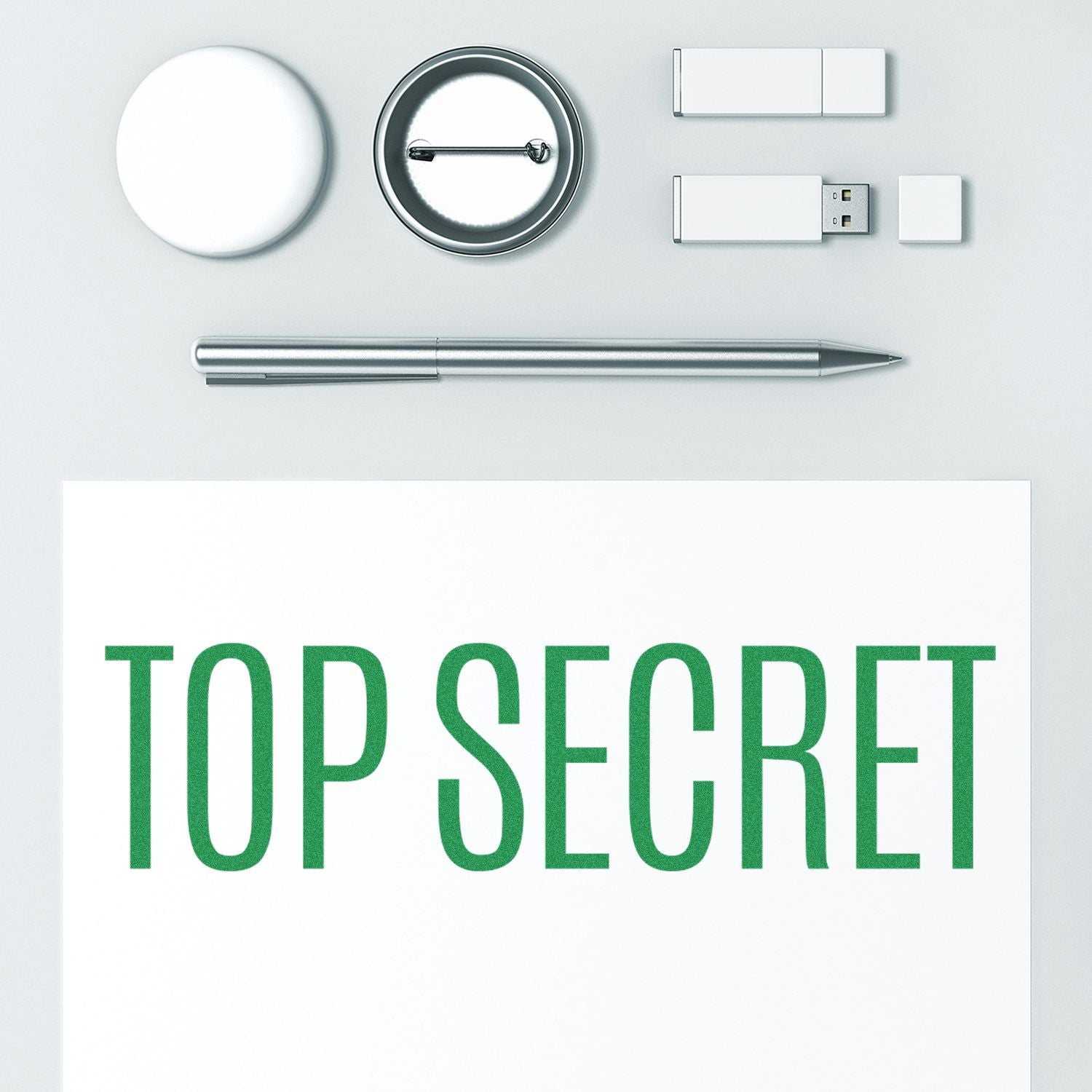 Top Secret rubber stamp on a white paper with a pen, badge, USB drives, and a round object arranged neatly on a light surface.