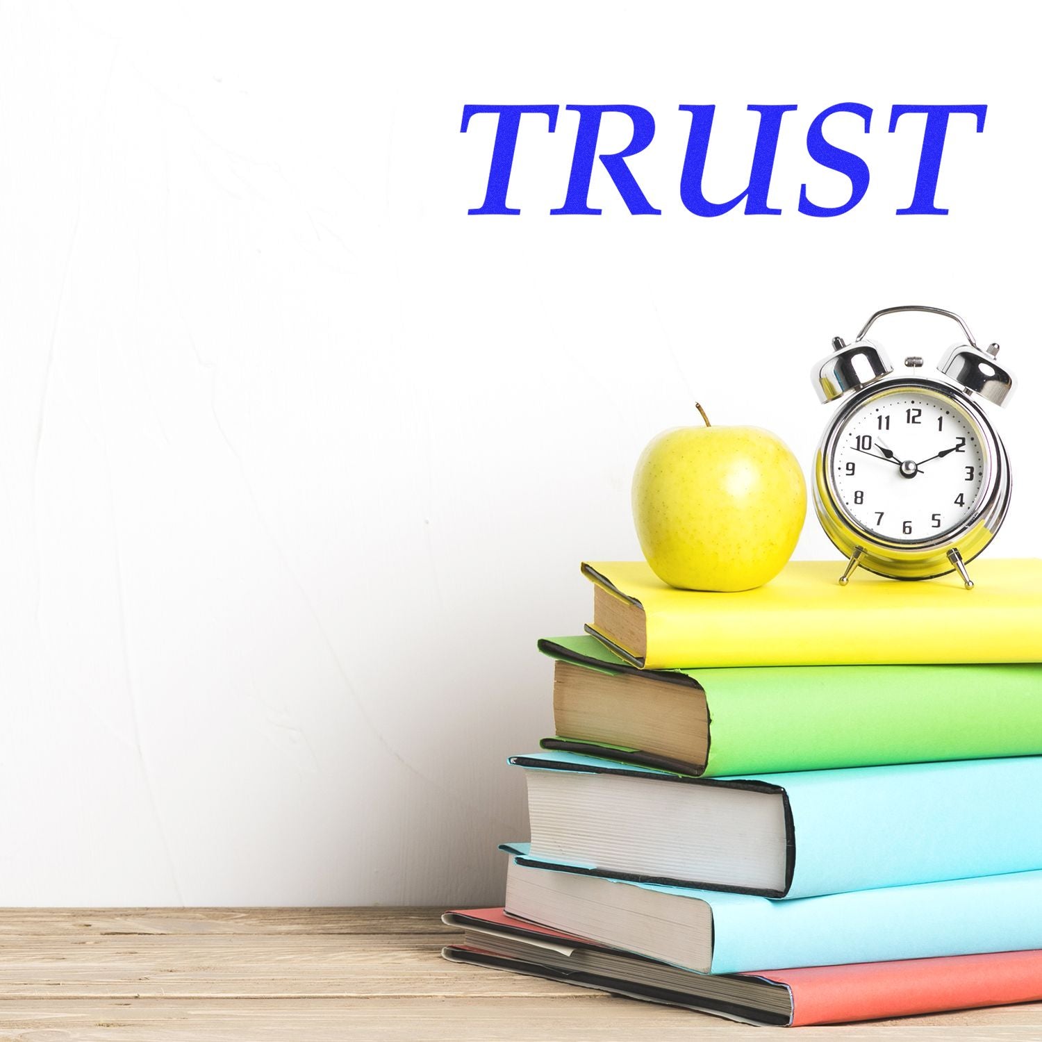 Large Trust rubber stamp image with the word TRUST above a stack of colorful books, an apple, and an alarm clock.