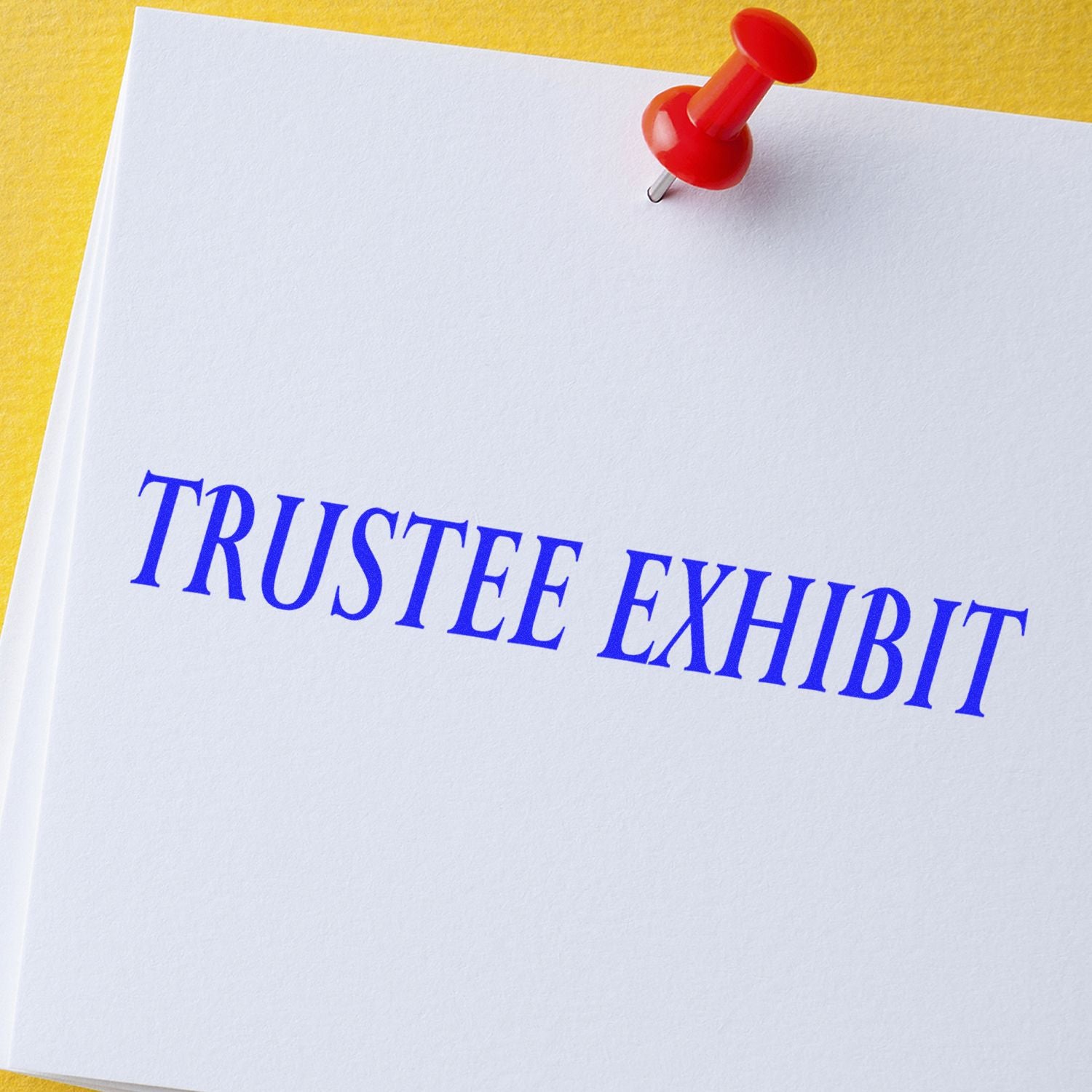 Trustee Exhibit rubber stamp impression on white paper with a red pushpin on a yellow background.