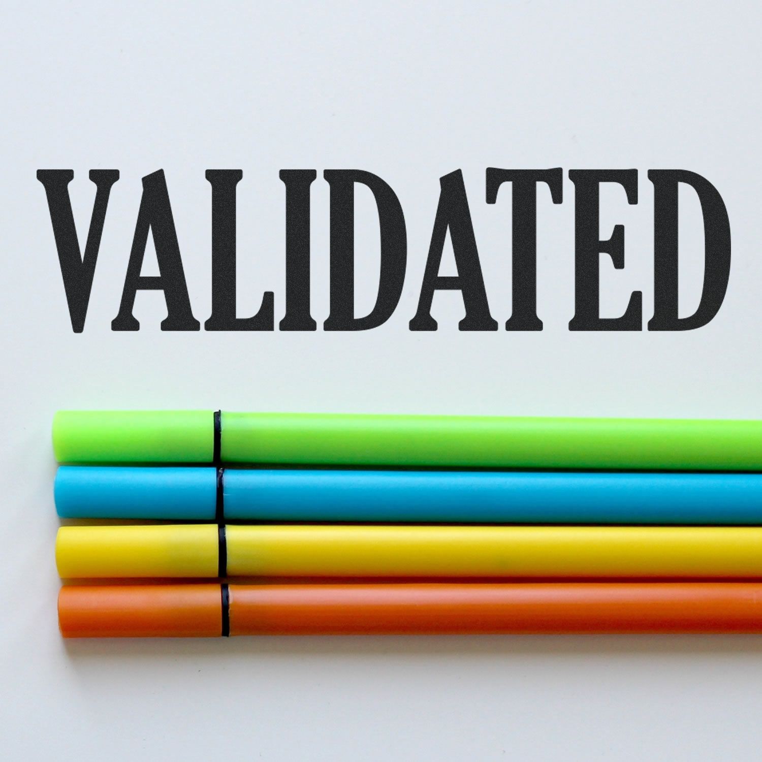 Self Inking Validated Stamp marking 'VALIDATED' on paper with colorful pens below the text.