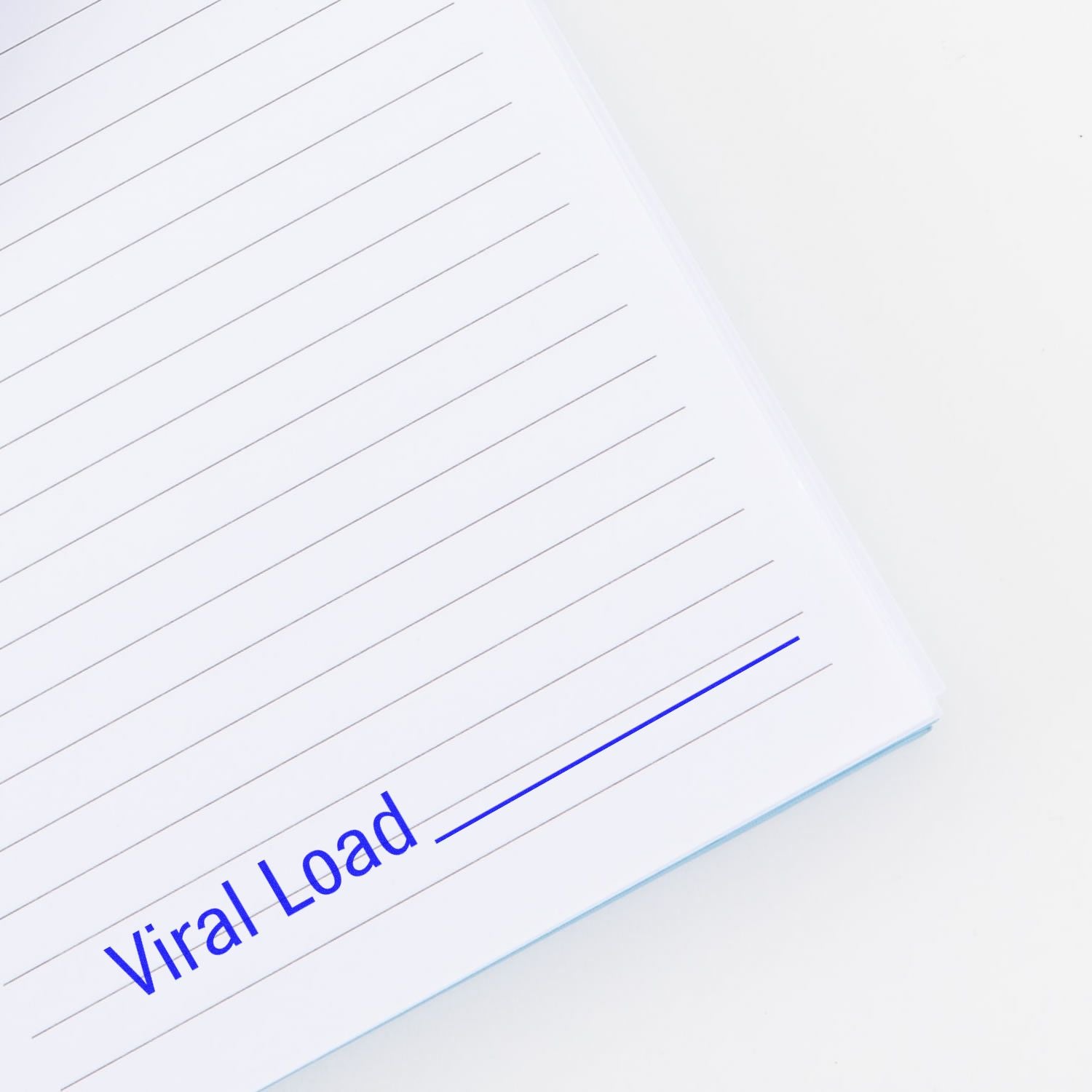 Slim Pre-Inked Viral Load Stamp marking Viral Load in blue ink on a lined white notebook page.