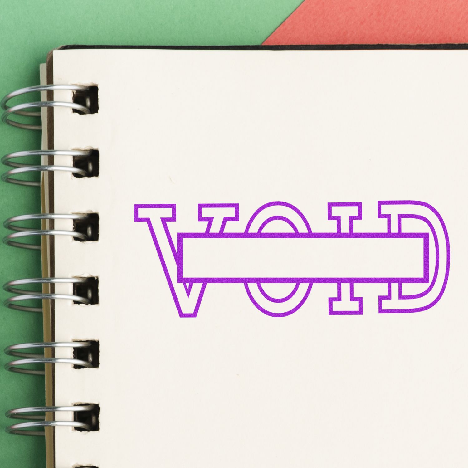 Notebook with a purple 'VOID' with box rubber stamp impression on a page, spiral binding visible on the left.