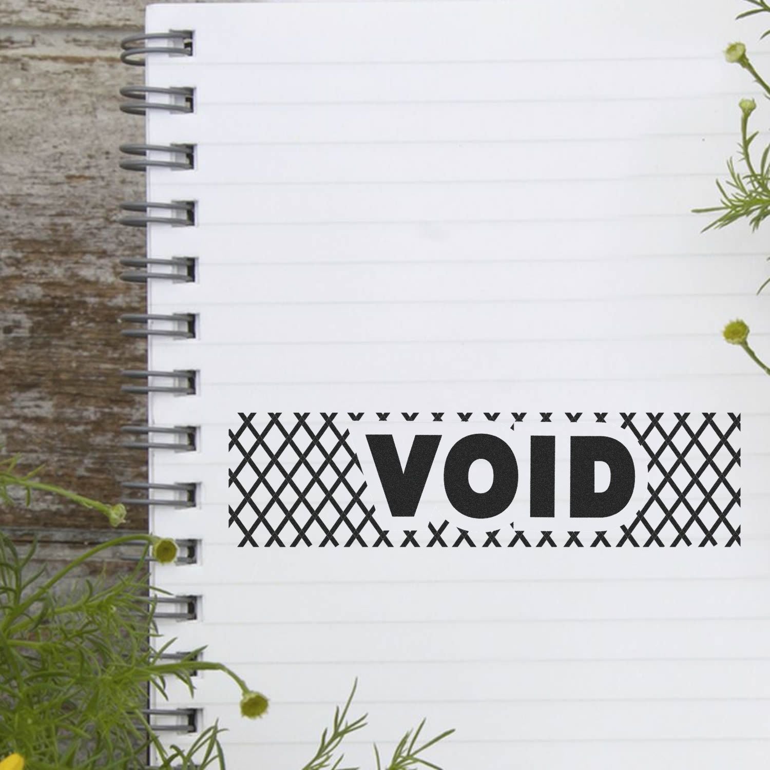 Large Pre-Inked Void with Strikelines Stamp used on a lined notebook, showing a bold VOID text with strikelines, surrounded by plants.