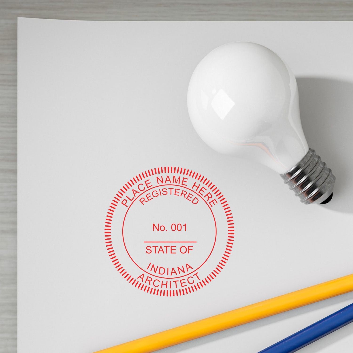 Digital Indiana Architect Stamp, Electronic Seal for Indiana Architect, displayed on white paper with a light bulb and pencils nearby.