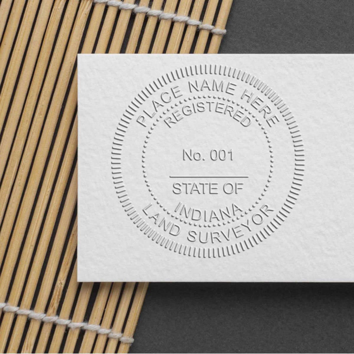 Another Example of a stamped impression of the State of Indiana Soft Land Surveyor Embossing Seal on a piece of office paper.