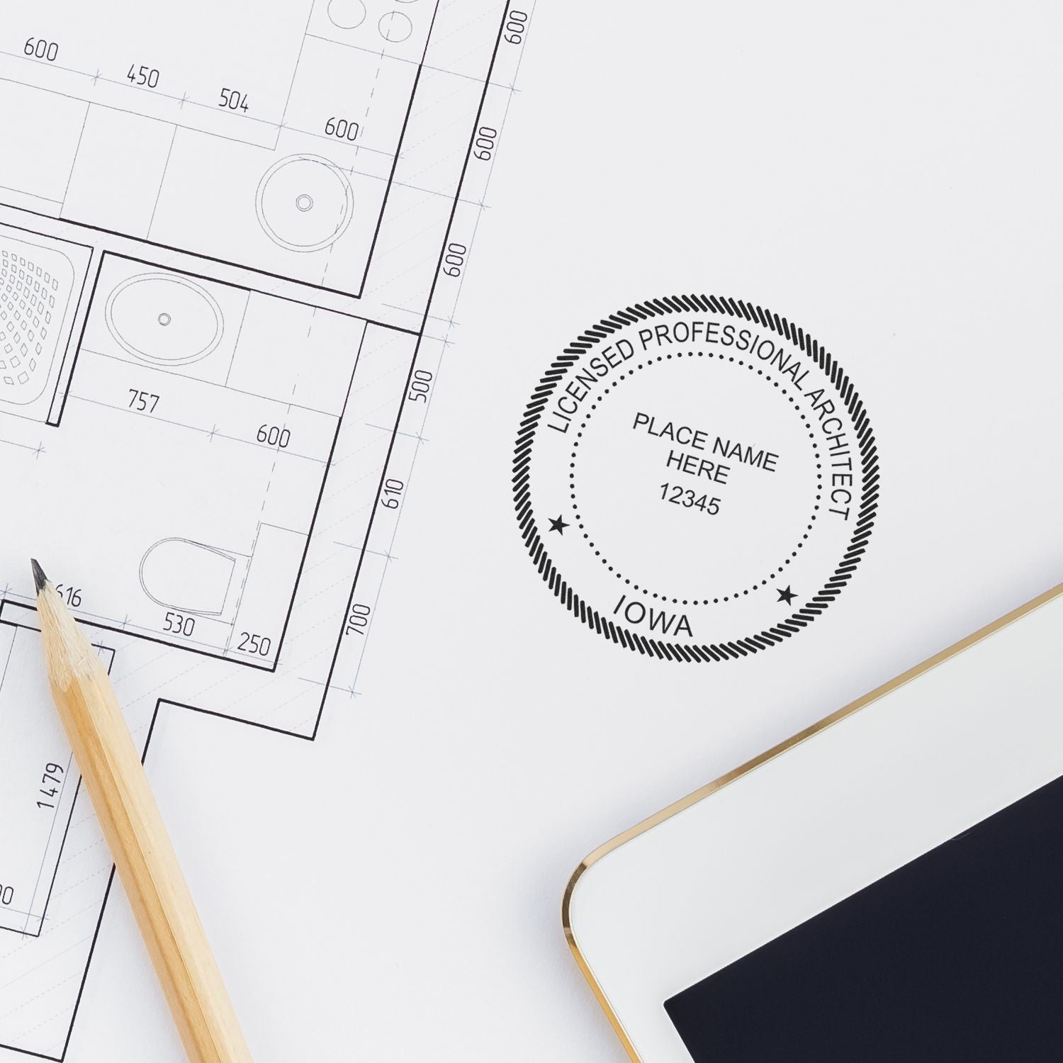 Iowa Architect Seal Stamp on a white paper next to a pencil, architectural blueprint, and a tablet.