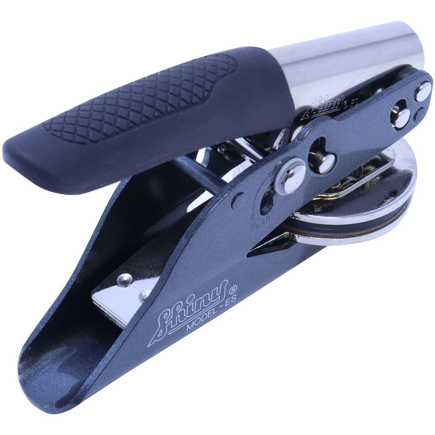 Public Weighmaster Soft Seal Embosser, angled side view, featuring a black handle with textured grip and a shiny metallic embossing mechanism.