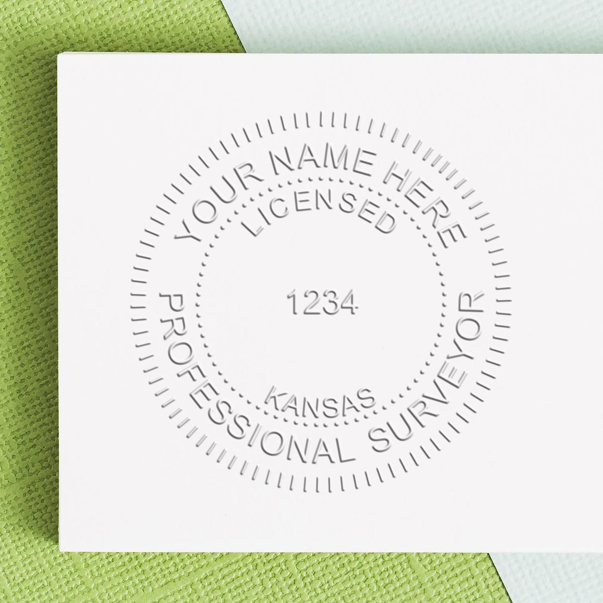 An in use photo of the Gift Kansas Land Surveyor Seal showing a sample imprint on a cardstock