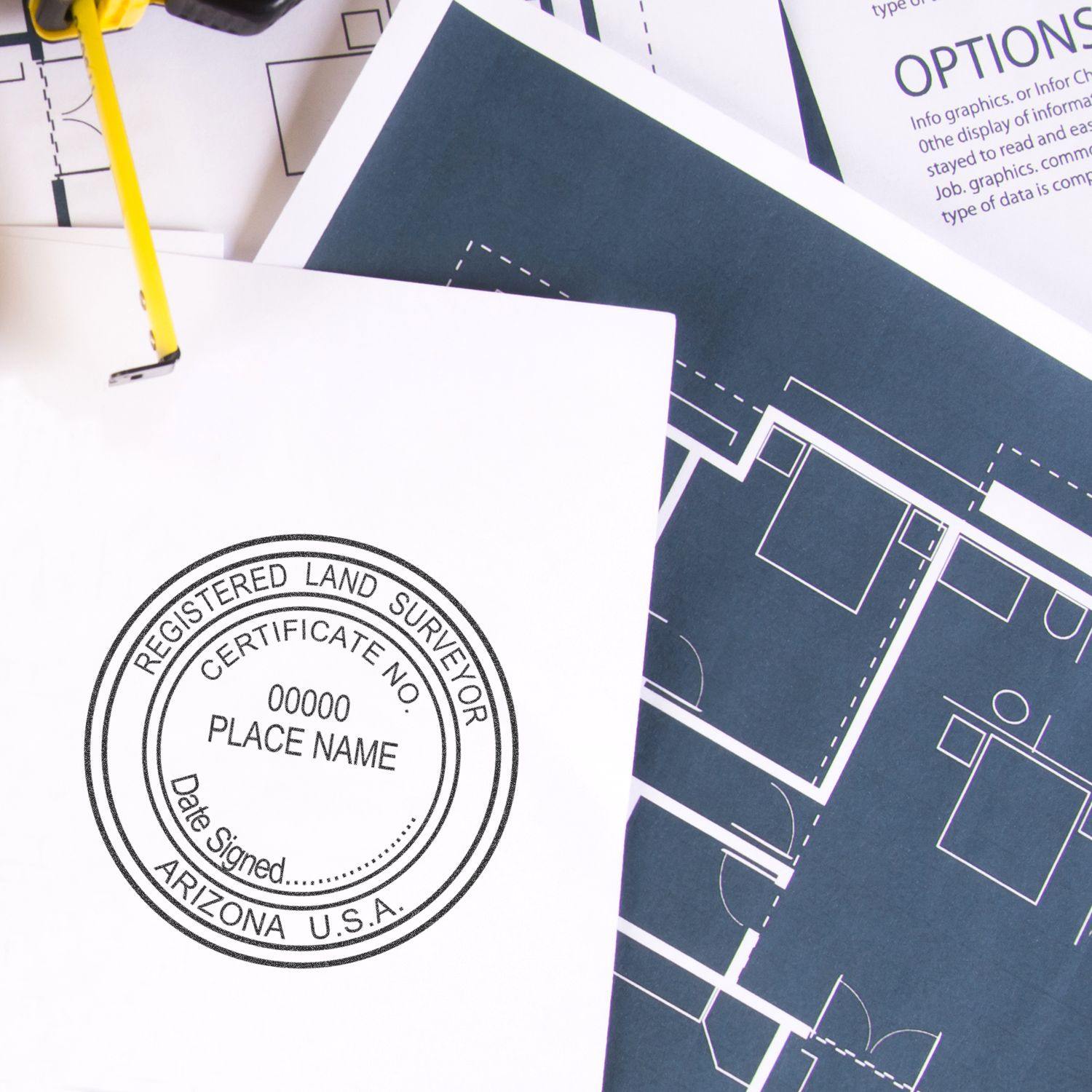 Land Surveyor Regular Rubber Stamp of Seal used on a document, next to architectural blueprints and a binder clip.