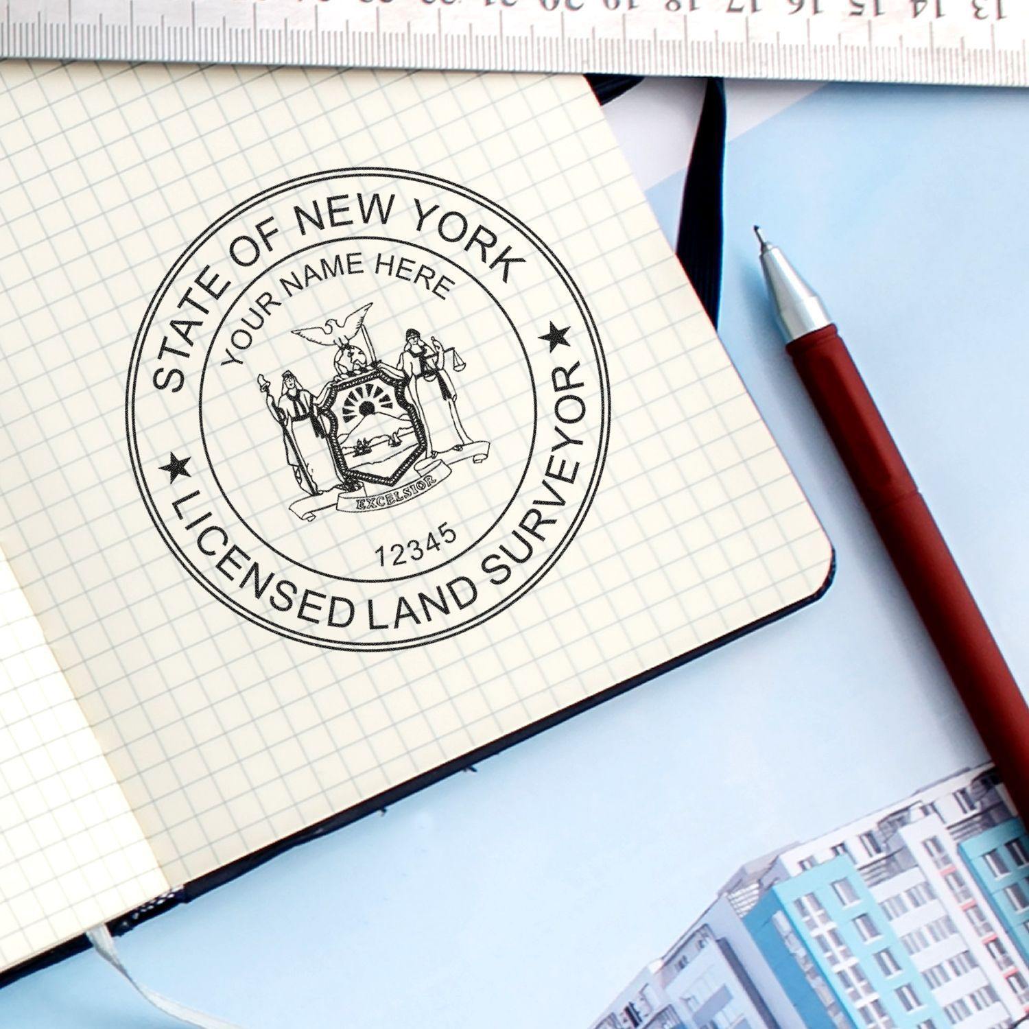 Land Surveyor Regular Rubber Stamp of Seal in use on a notebook, with a pen and ruler nearby, featuring State of New York Licensed Land Surveyor.