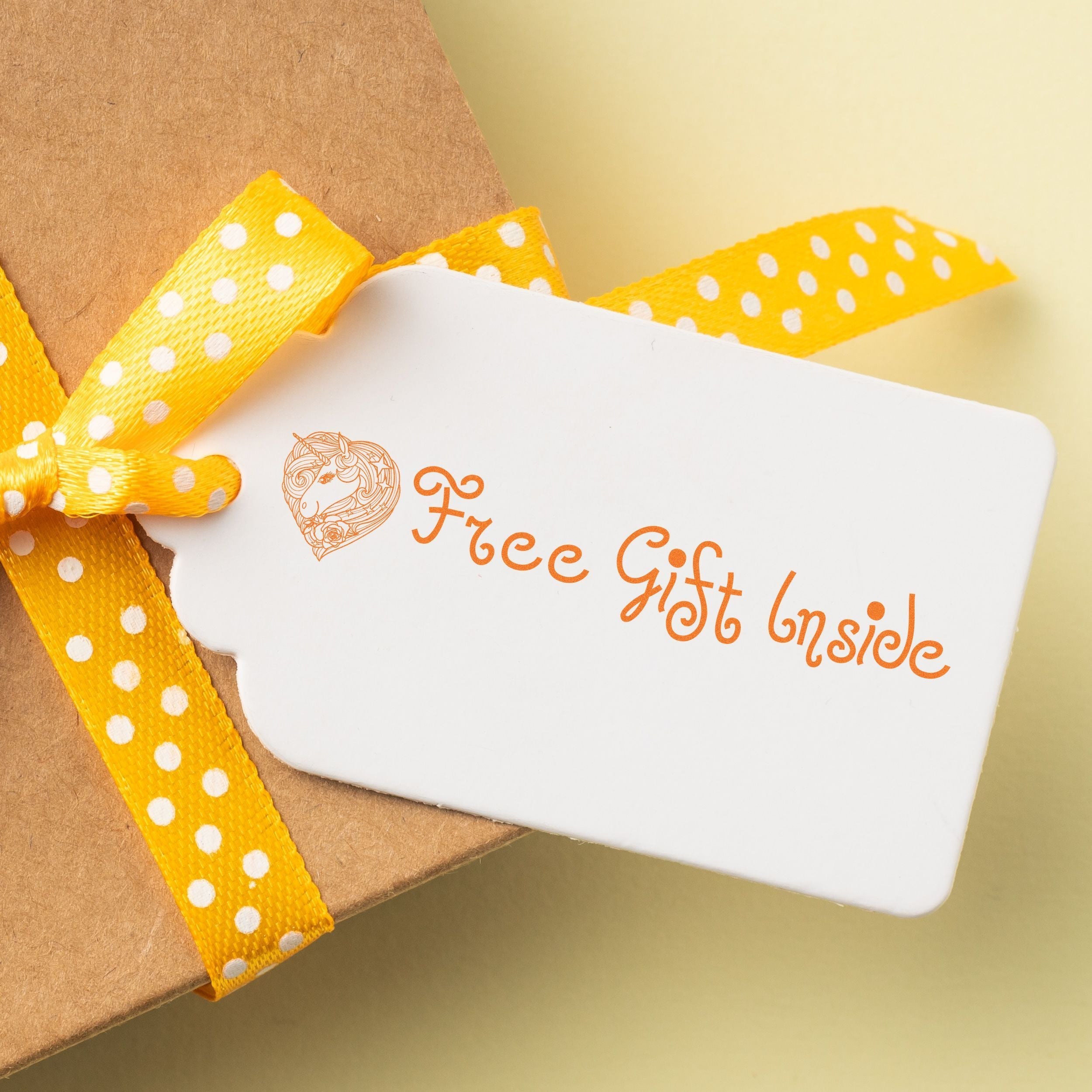 Gift tag stamped with Free Gift Inside using Custom Self Inking Stamp Trodat 4929 Size 1-3/16 x 2, attached to a box with a yellow ribbon.