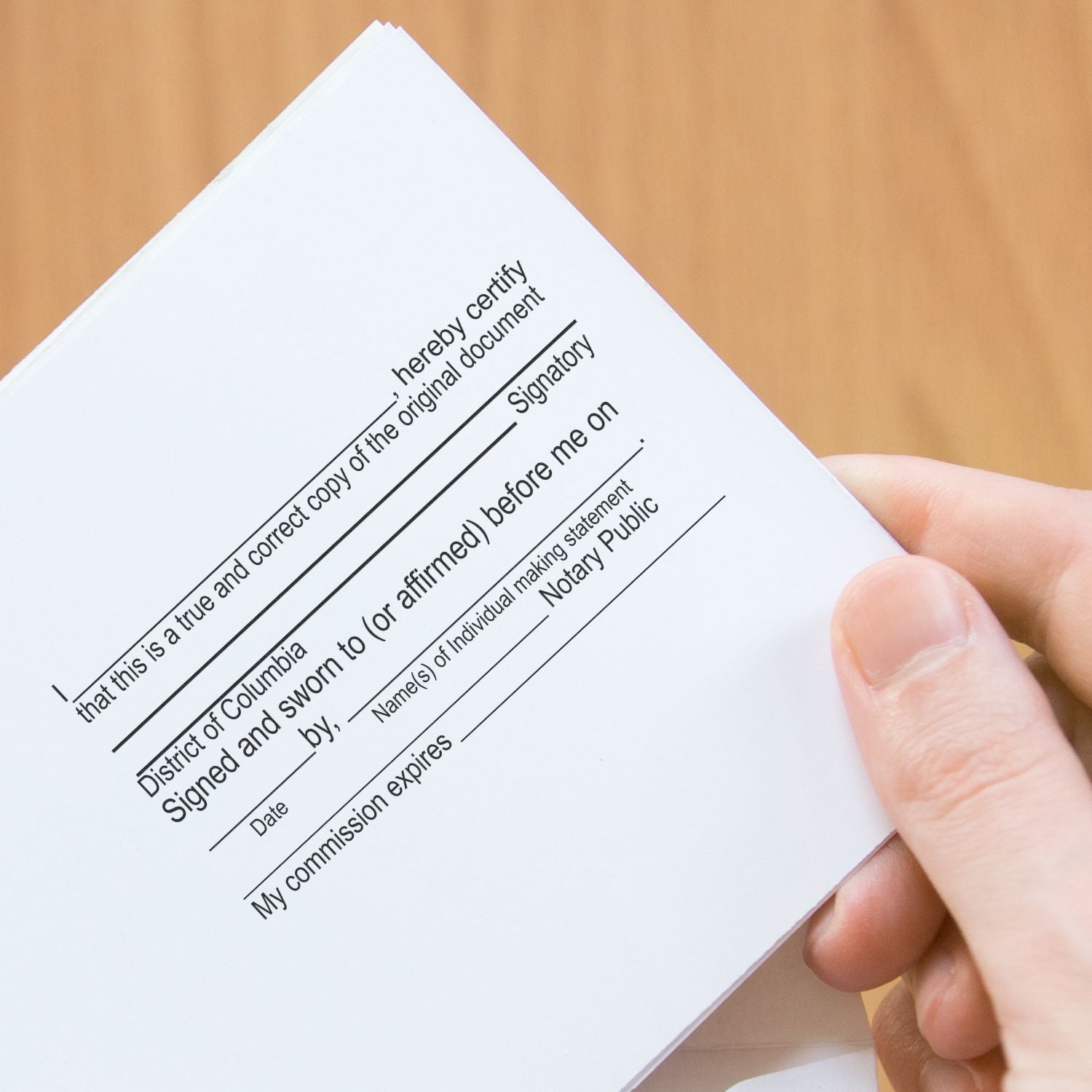 Person holding a document stamped with a 10 Line Custom Rubber Stamp with Wood Handle, showing a notary public template.