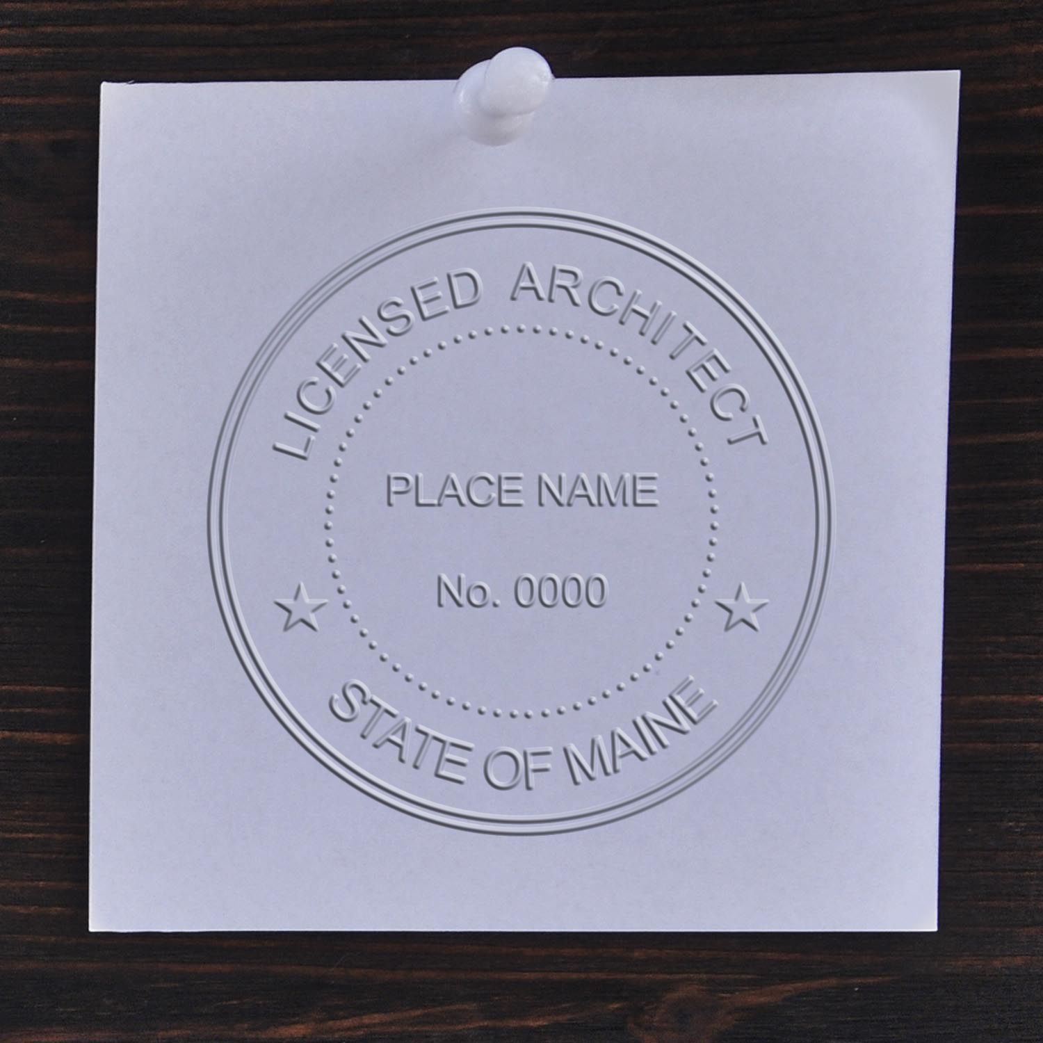 A lifestyle photo showing a stamped image of the Maine Desk Architect Embossing Seal on a piece of paper