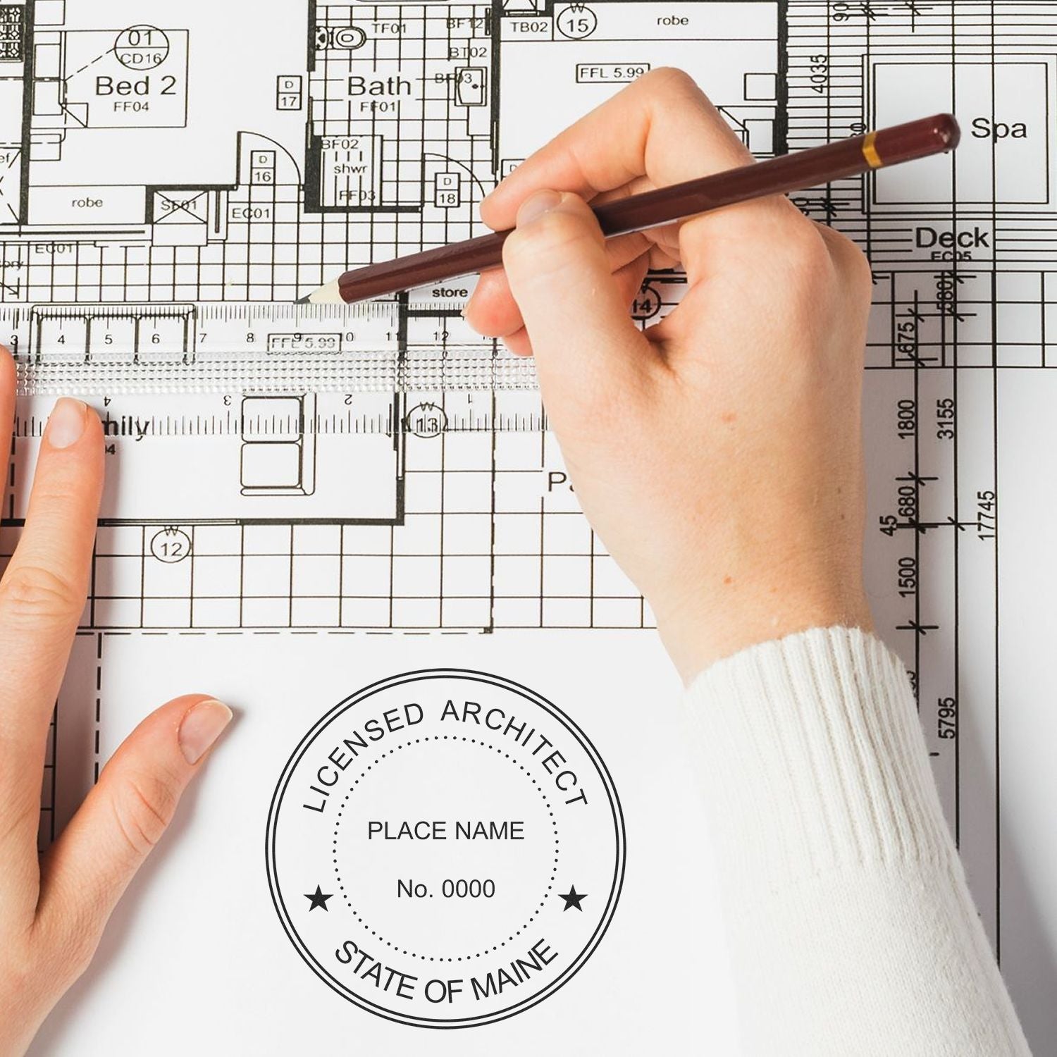 Person using a ruler and pen on architectural plans with a Self Inking Maine Architect Stamp imprint visible on the paper.