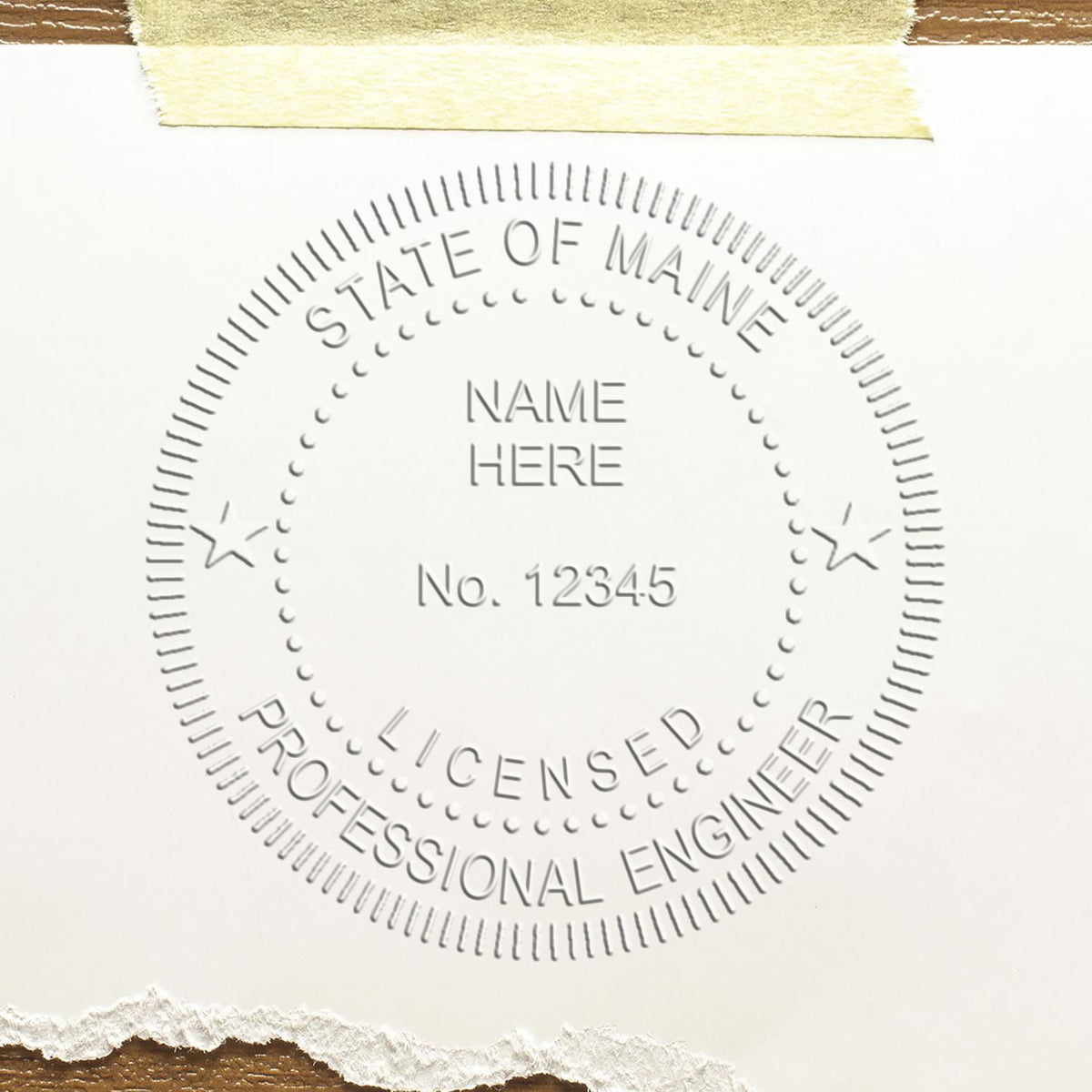 A lifestyle photo showing a stamped image of the Handheld Maine Professional Engineer Embosser on a piece of paper