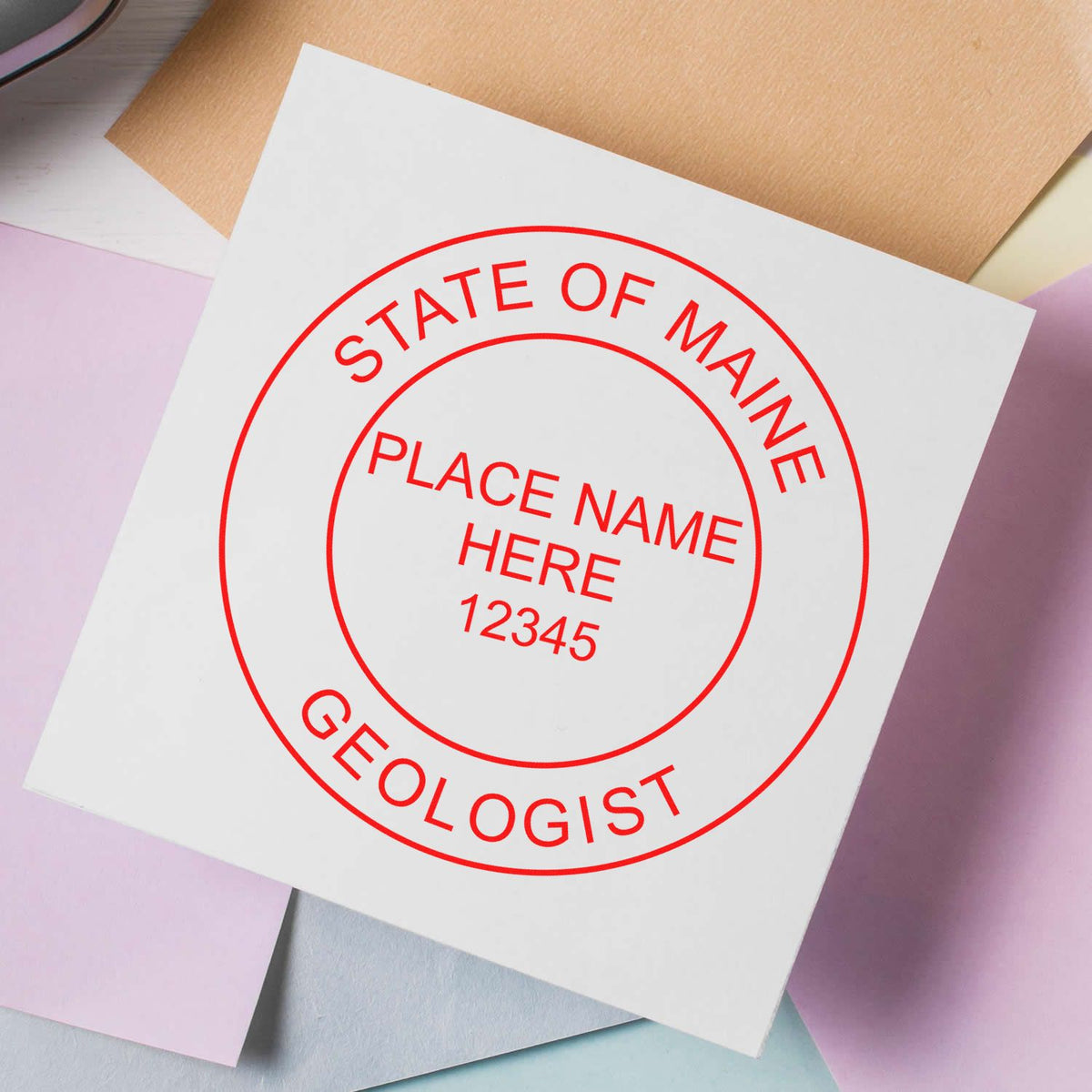 An in use photo of the Slim Pre-Inked Maine Professional Geologist Seal Stamp showing a sample imprint on a cardstock