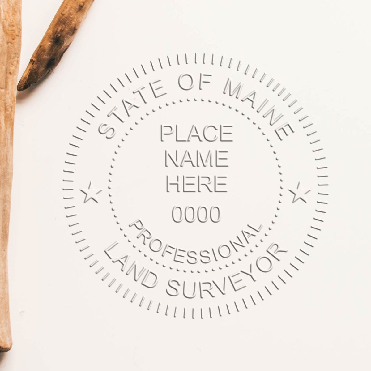 An in use photo of the Hybrid Maine Land Surveyor Seal showing a sample imprint on a cardstock