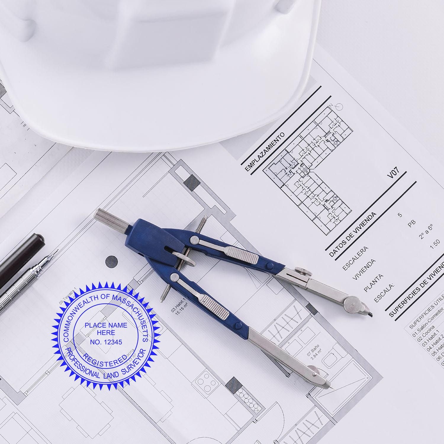 Self Inking Massachusetts Land Surveyor Stamp on architectural plans with a compass, pen, and hard hat in the background.