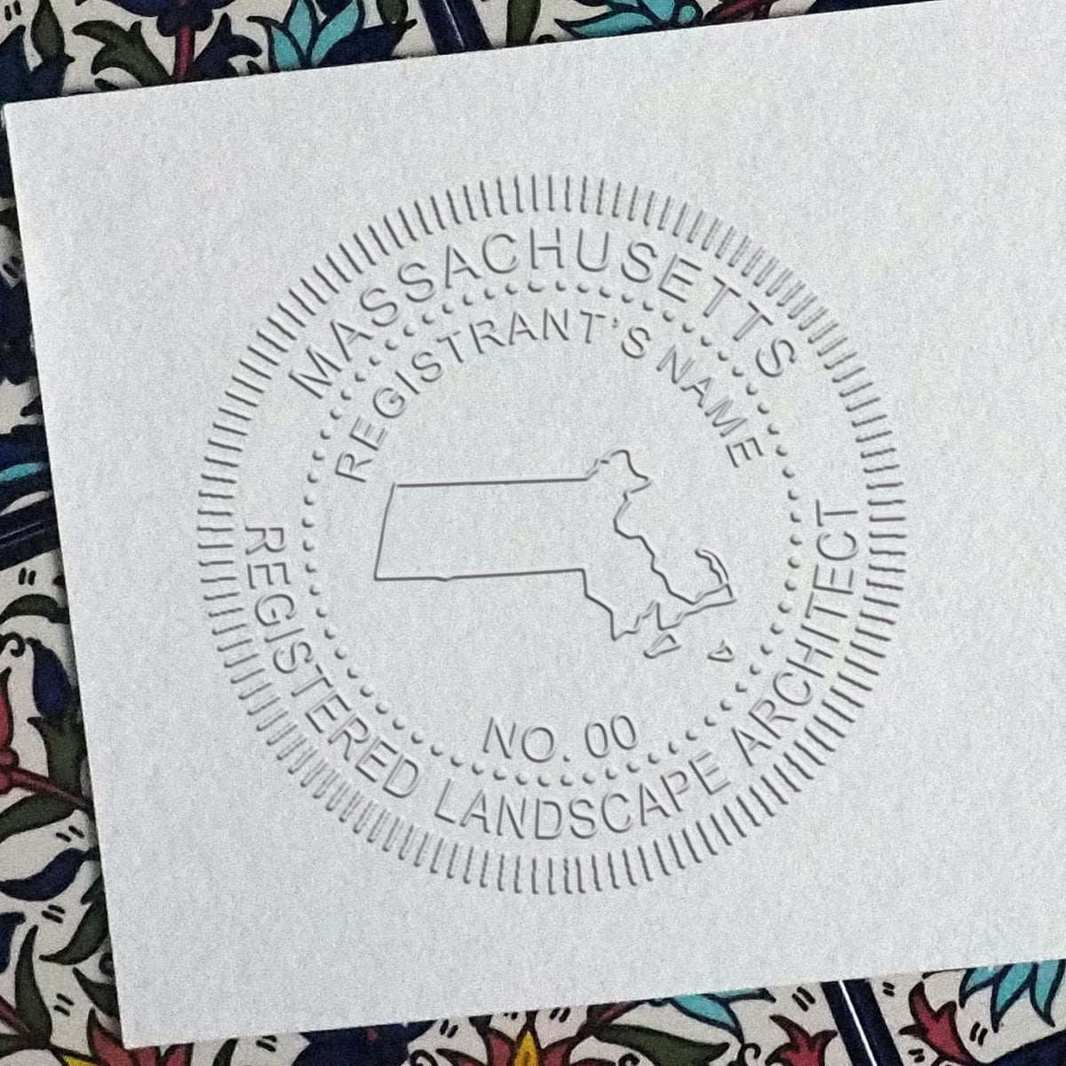 An in use photo of the Hybrid Massachusetts Landscape Architect Seal showing a sample imprint on a cardstock