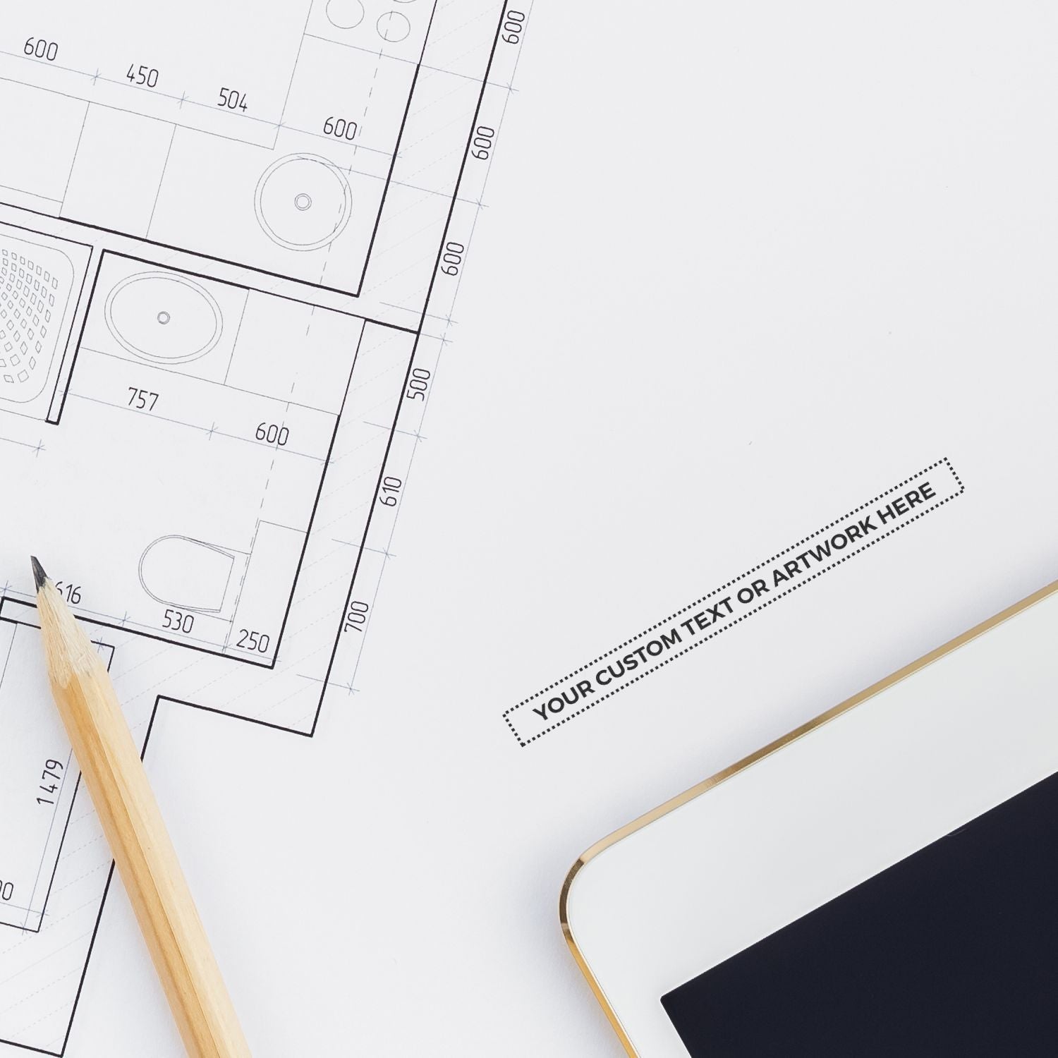 MaxLight XL2-55 Custom Pre-Inked Business Stamp 3/16 x 2-1/2 used on architectural plans, next to a pencil and tablet.