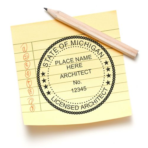 A Michigan Architect Seal Stamp on a yellow notepad with a pencil. The stamp reads "State of Michigan Licensed Architect" with space for details.