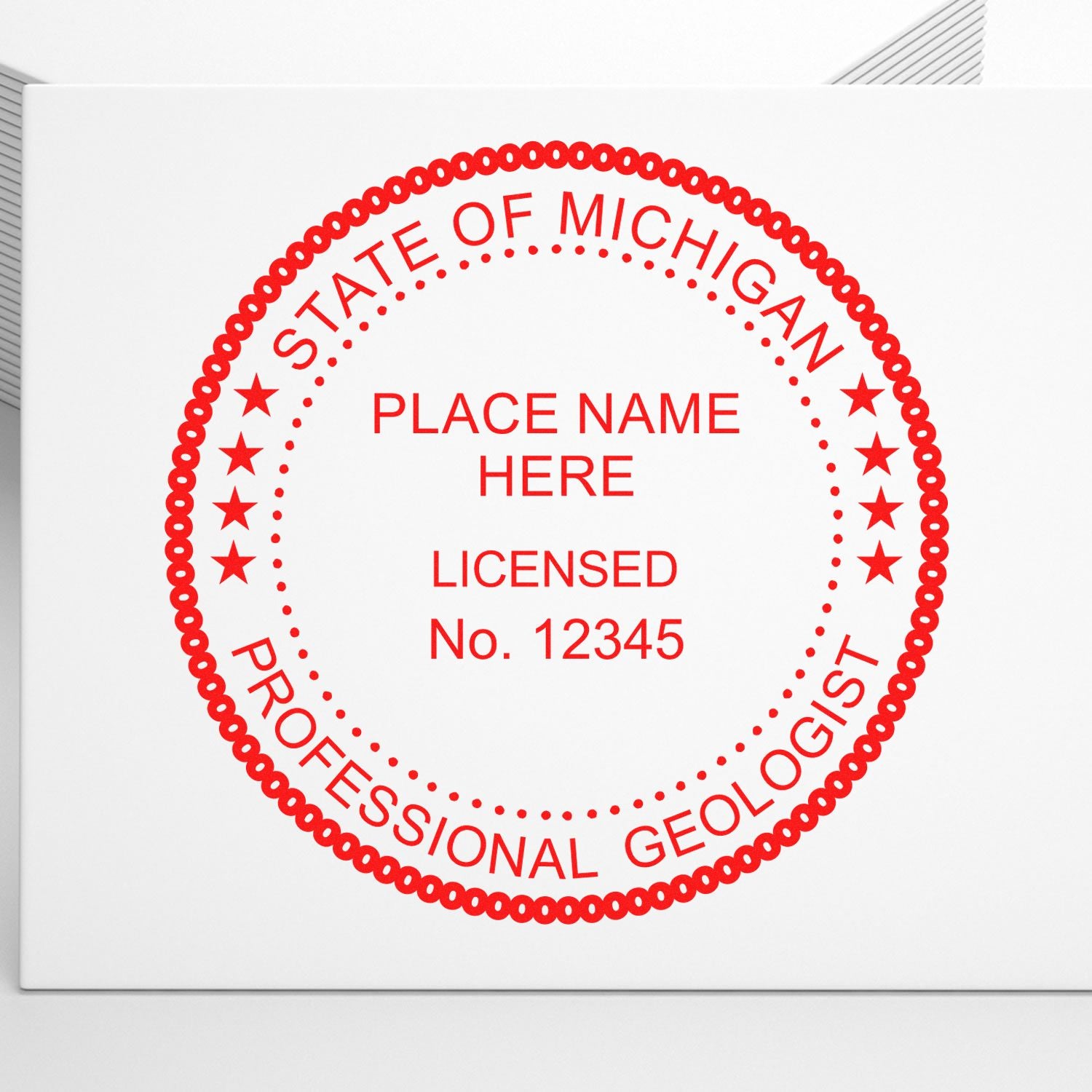 An in use photo of the Michigan Professional Geologist Seal Stamp showing a sample imprint on a cardstock