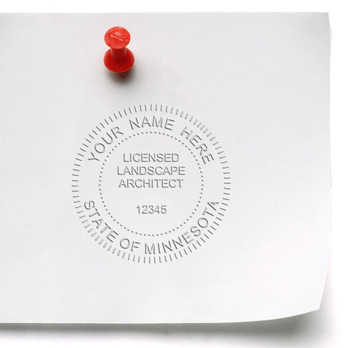 An in use photo of the Gift Minnesota Landscape Architect Seal showing a sample imprint on a cardstock