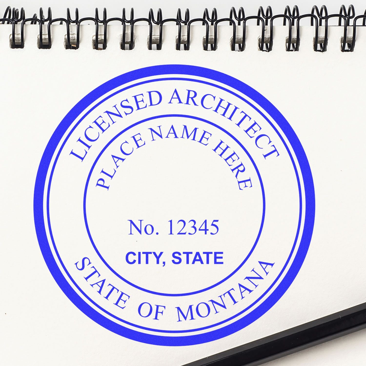 Digital Montana Architect Stamp, Electronic Seal for Montana Architect, displayed on a spiral notebook with a pen nearby.