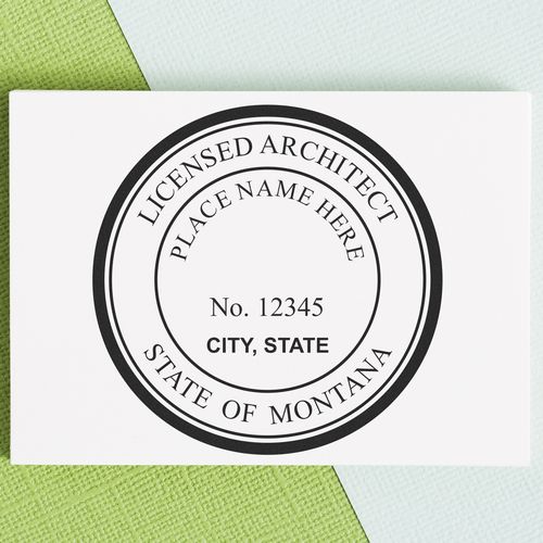 Premium MaxLight Pre-Inked Montana Architectural Stamp on a textured green and blue background, displaying a customizable licensed architect seal.