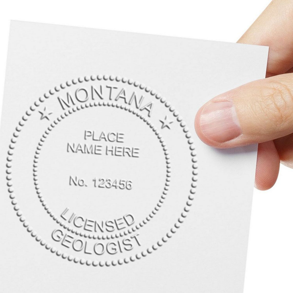 A lifestyle photo showing a stamped image of the Handheld Montana Professional Geologist Embosser on a piece of paper