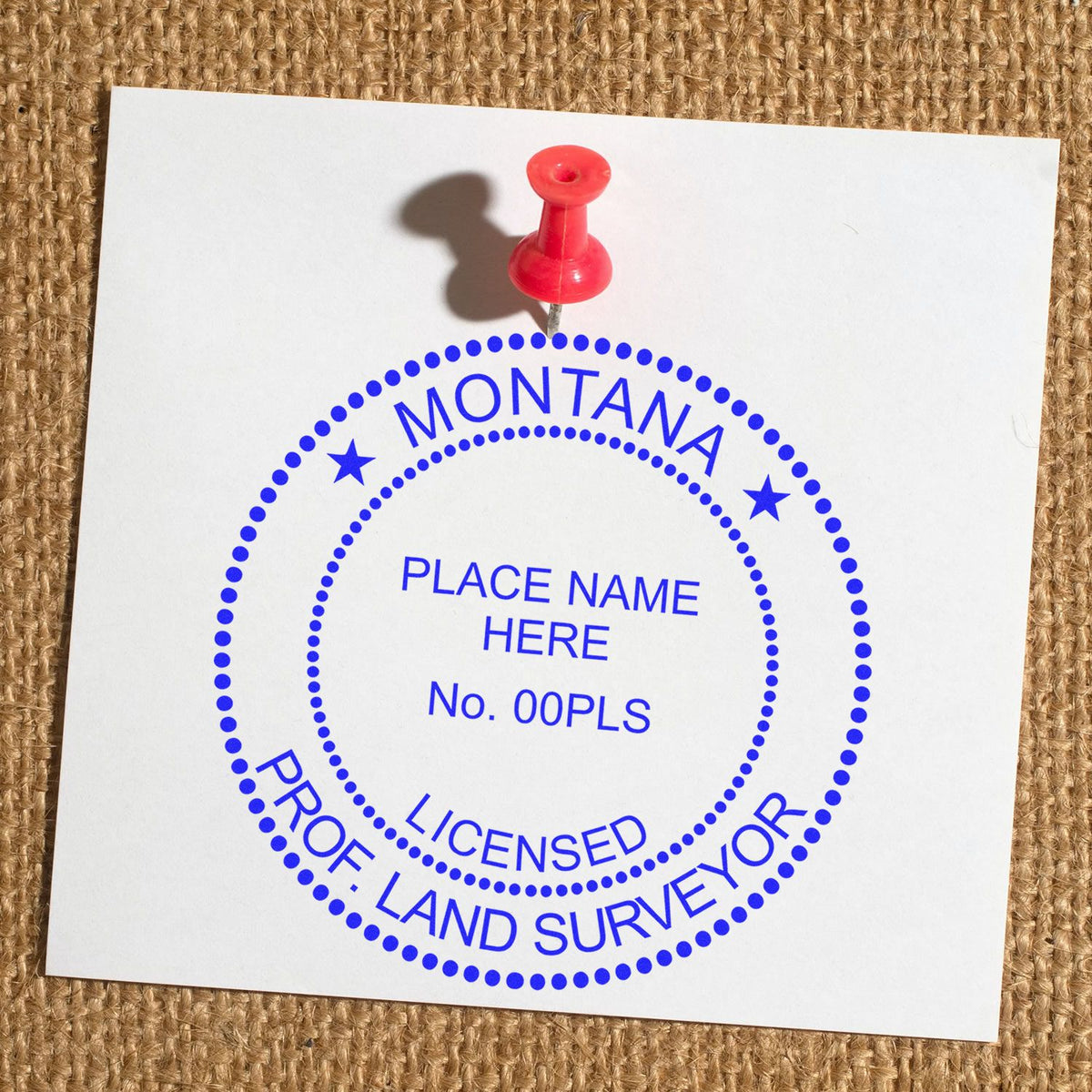A lifestyle photo showing a stamped image of the Slim Pre-Inked Montana Land Surveyor Seal Stamp on a piece of paper