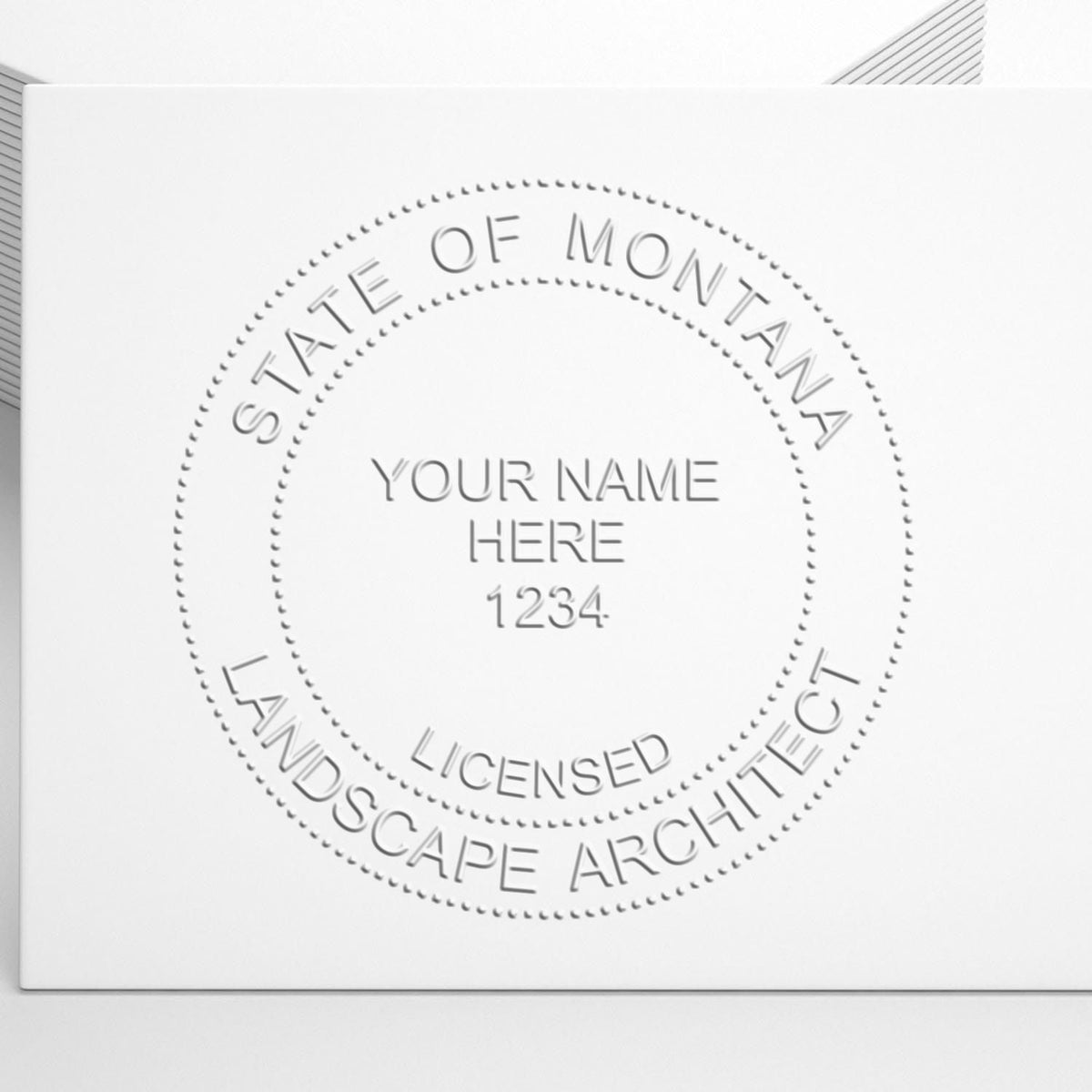 An in use photo of the Hybrid Montana Landscape Architect Seal showing a sample imprint on a cardstock