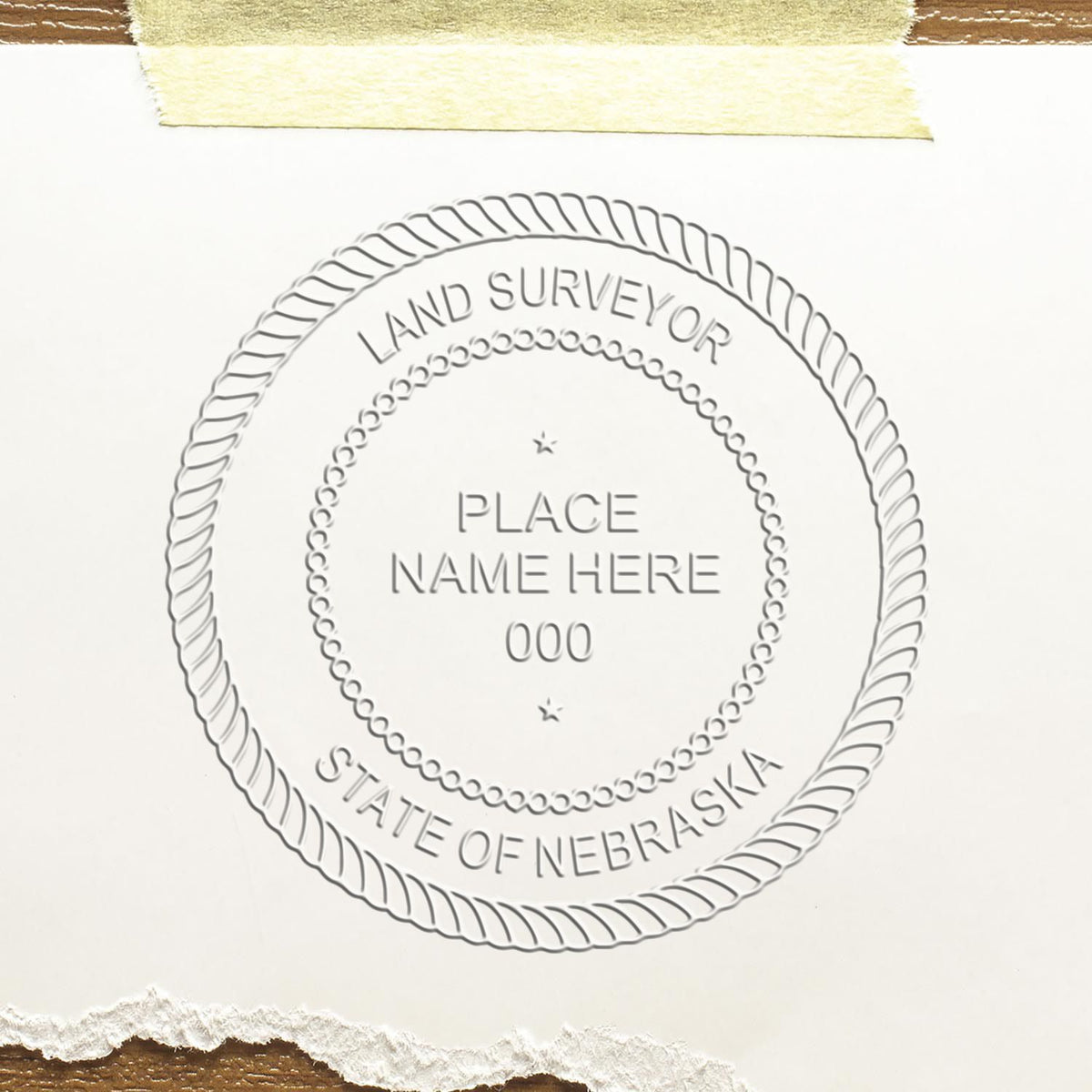 A lifestyle photo showing a stamped image of the Handheld Nebraska Land Surveyor Seal on a piece of paper