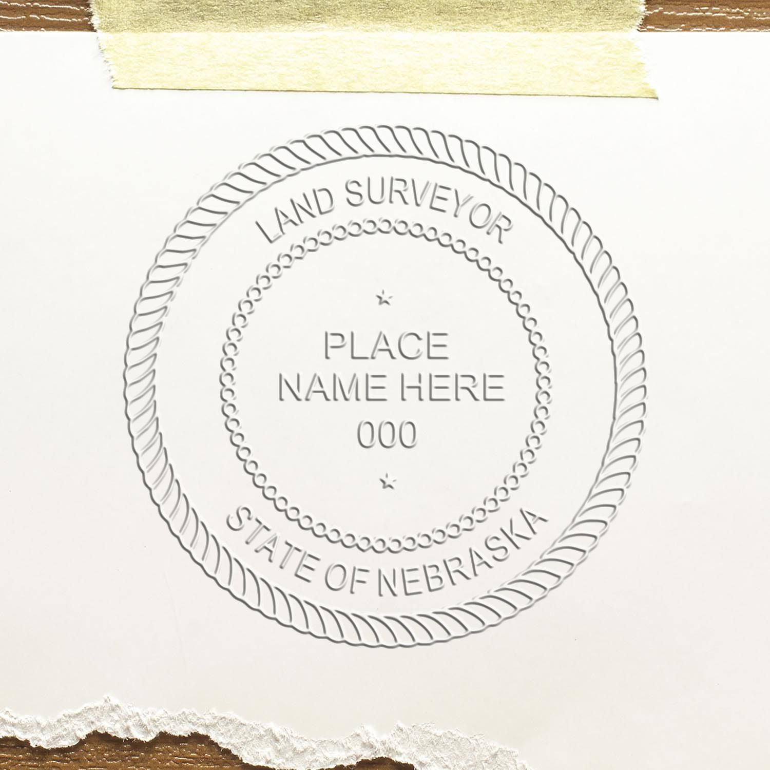 An in use photo of the Hybrid Nebraska Land Surveyor Seal showing a sample imprint on a cardstock