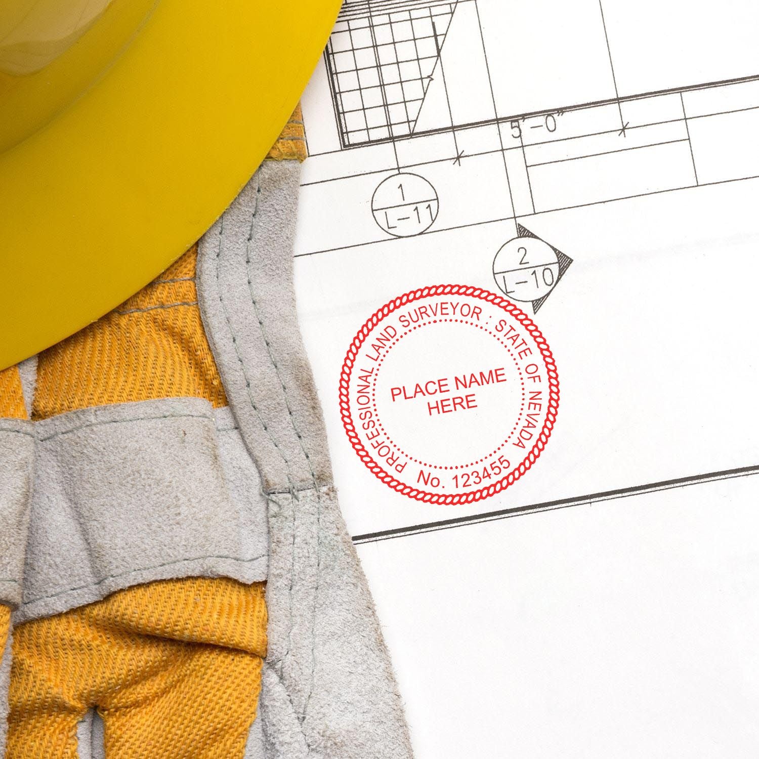 Premium MaxLight Pre-Inked Nevada Surveyors Stamp on a technical drawing next to a yellow hard hat and gloves.