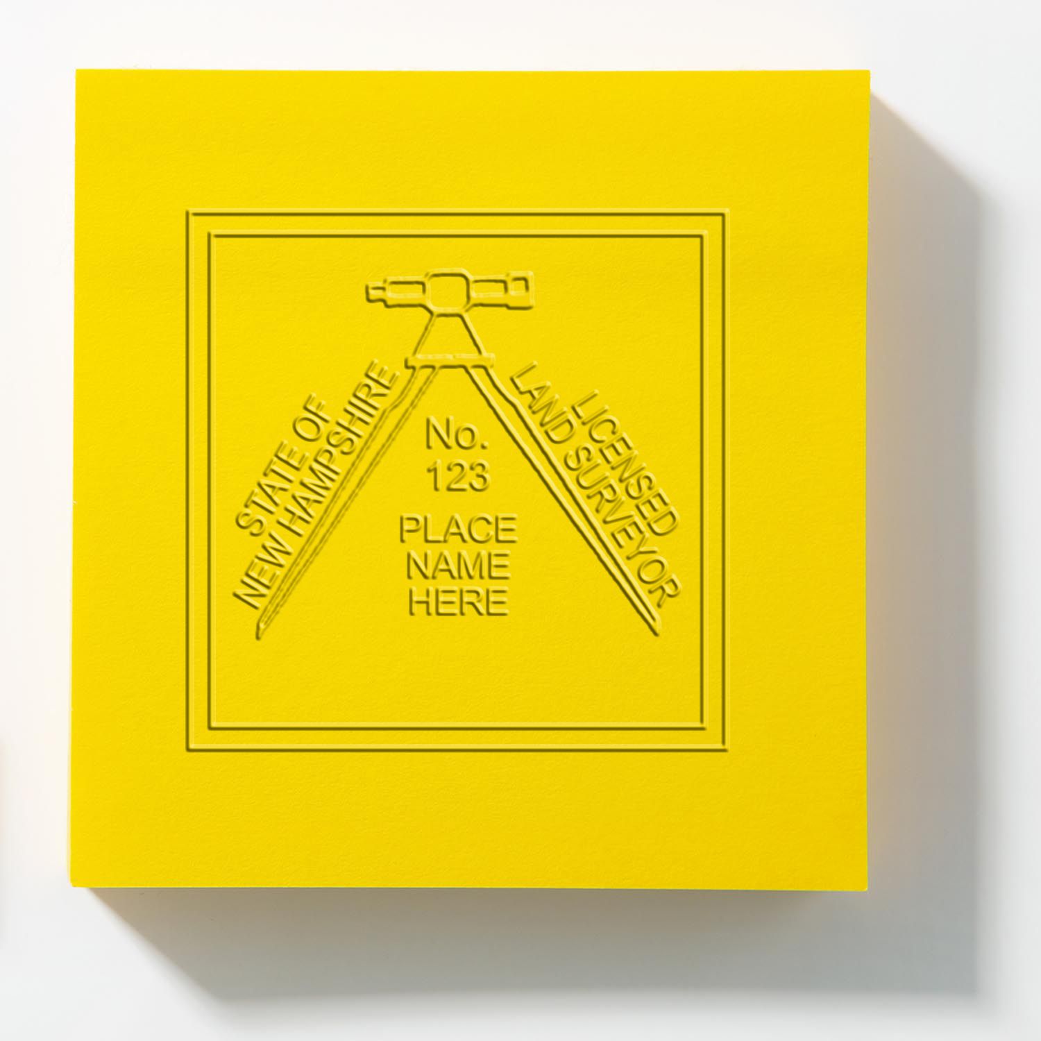 An alternative view of the Handheld New Hampshire Land Surveyor Seal stamped on a sheet of paper showing the image in use