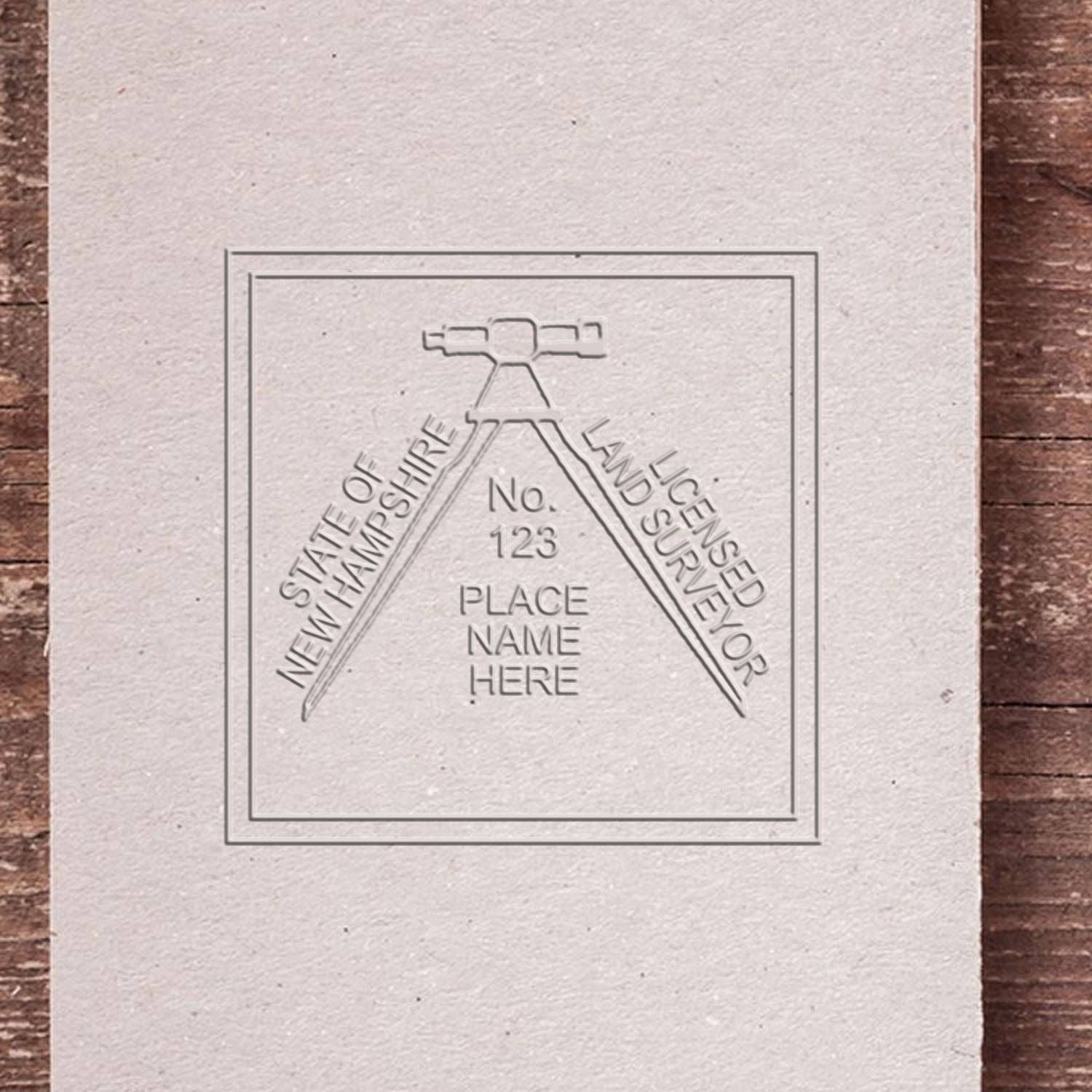 An alternative view of the Heavy Duty Cast Iron New Hampshire Land Surveyor Seal Embosser stamped on a sheet of paper showing the image in use