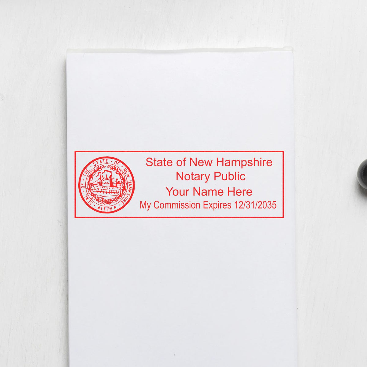 An alternative view of the MaxLight Premium Pre-Inked New Hampshire State Seal Notarial Stamp stamped on a sheet of paper showing the image in use