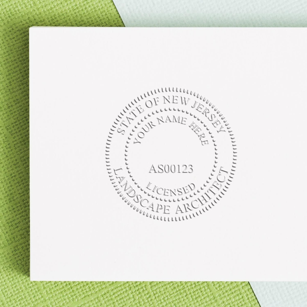 An in use photo of the Gift New Jersey Landscape Architect Seal showing a sample imprint on a cardstock