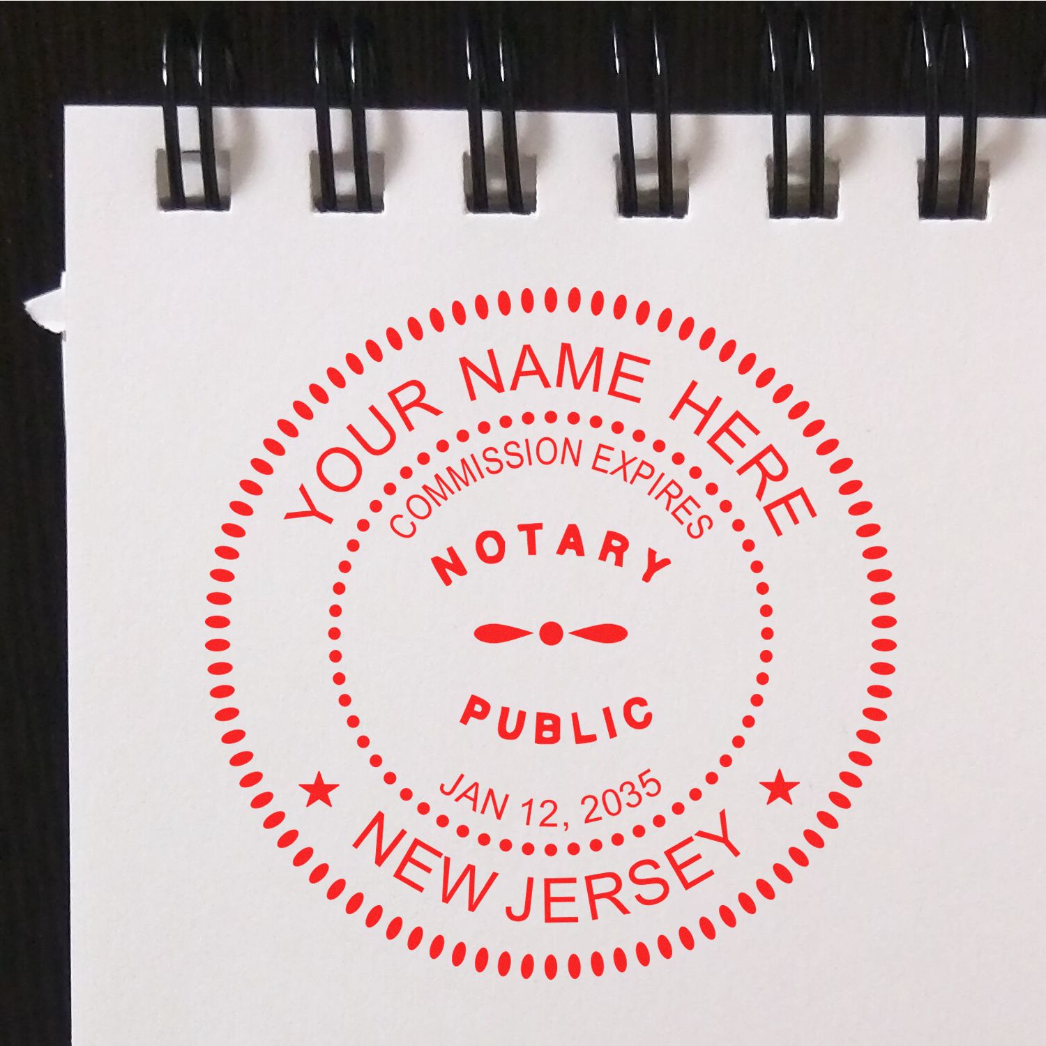 An alternative view of the Official Self-Inking New Jersey Notary Stamp stamped on a sheet of paper showing the image in use