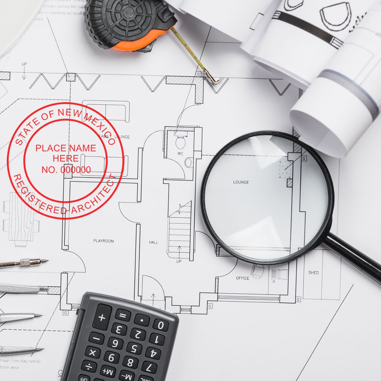 Self Inking New Mexico Architect Stamp on architectural blueprints with a magnifying glass, calculator, and measuring tape.